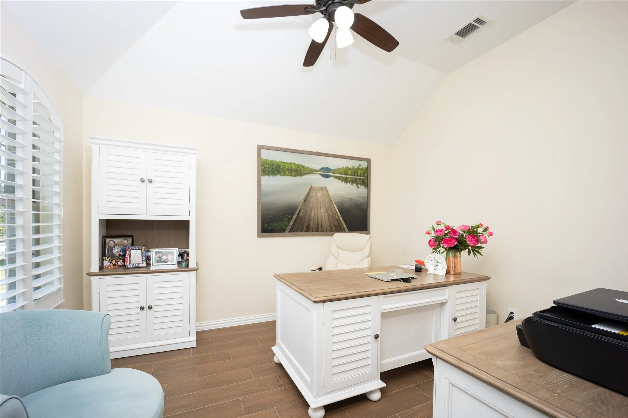 Vaulted ceiling room featuring wood-finish flooring