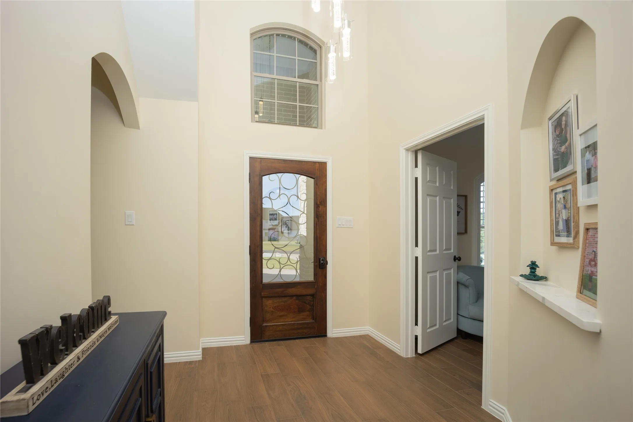 Grand entry featuring wood-finish flooring and a decorative glass-paneled front door