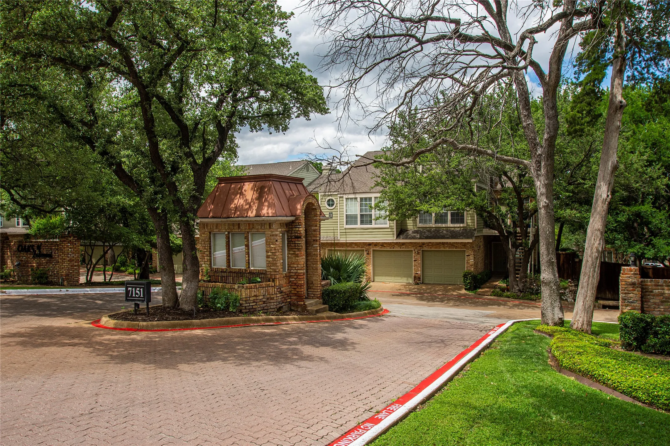 Brick paver entry drive featuring a brick and copper-roofed gatehouse