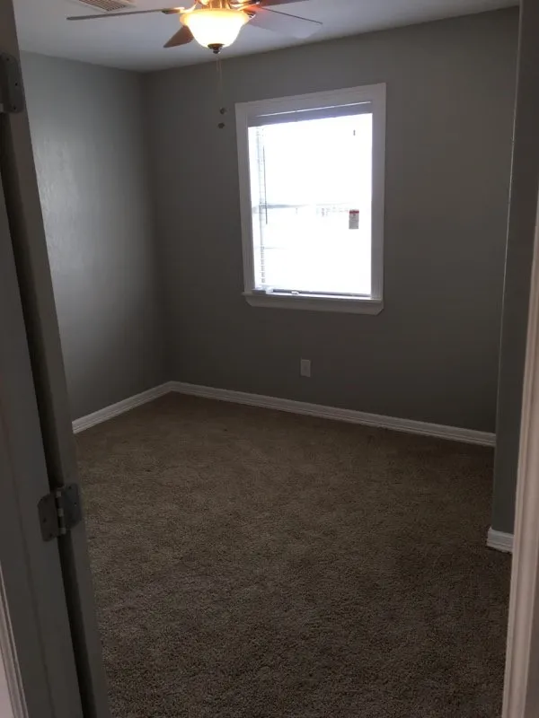 Spare room with ceiling fan and dark carpet