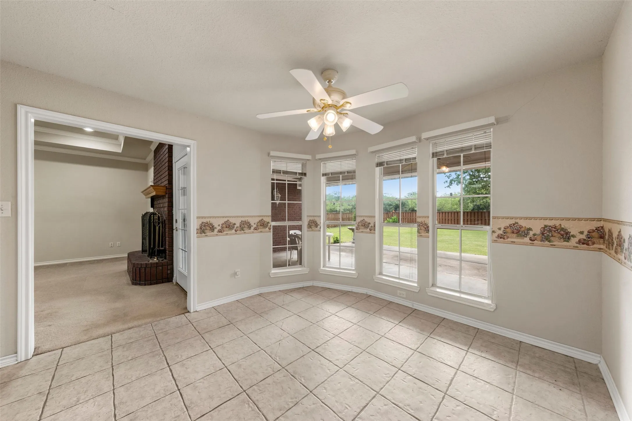 Tile flooring in a room featuring a multi-window wall overlooking the backyard