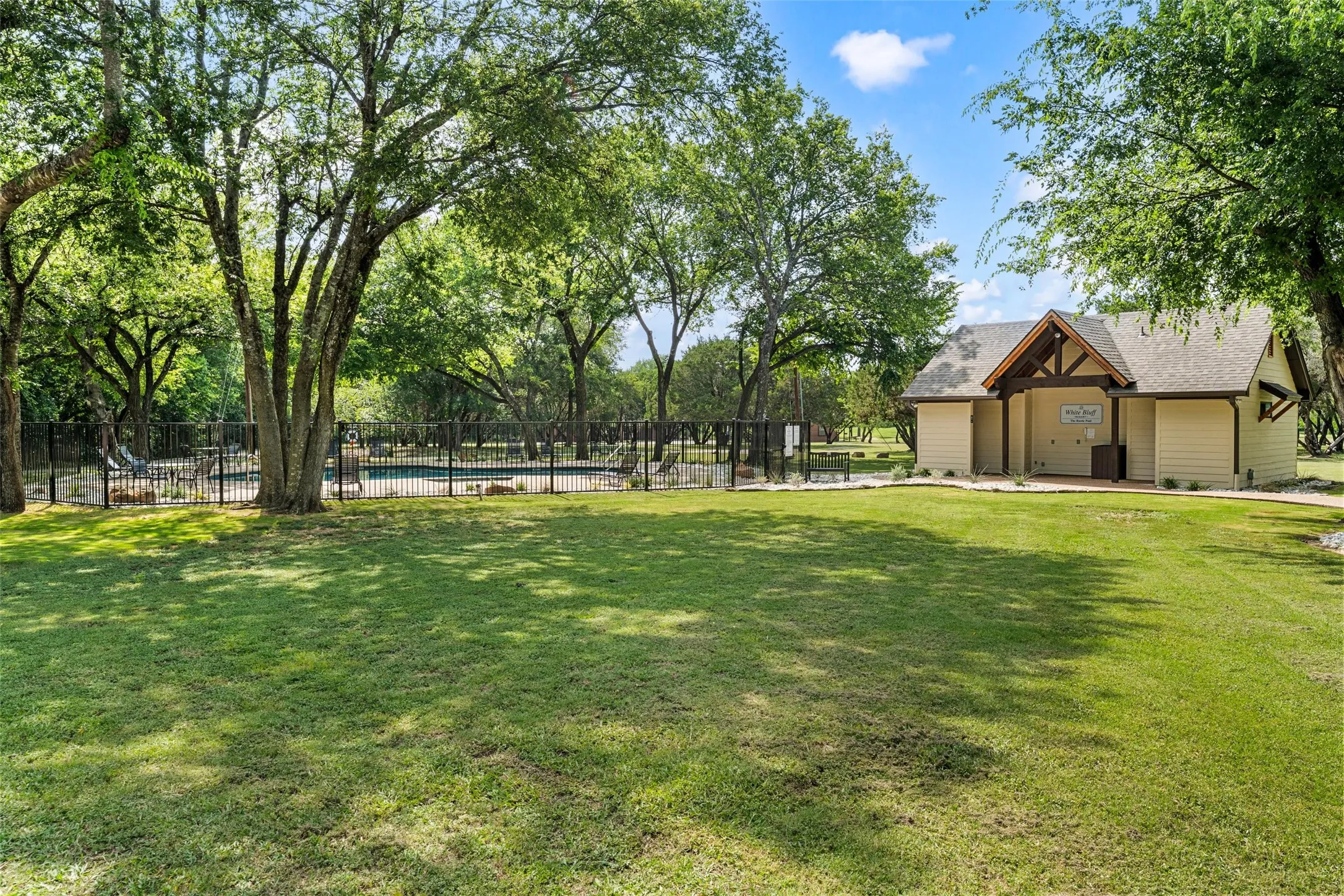 Expansive grassy lawn bordered by mature trees
