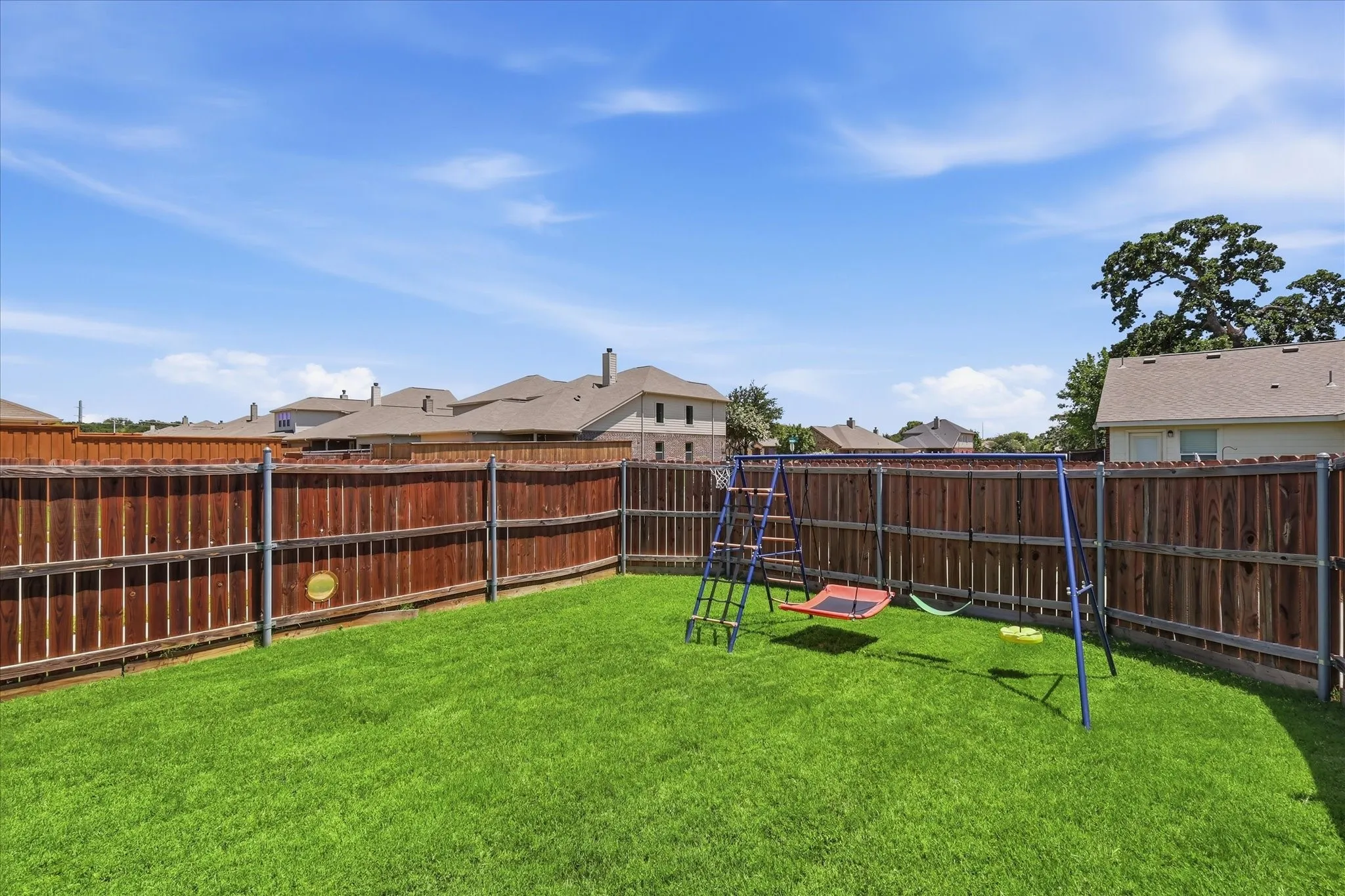 Fully fenced backyard featuring a manicured lawn and privacy fencing