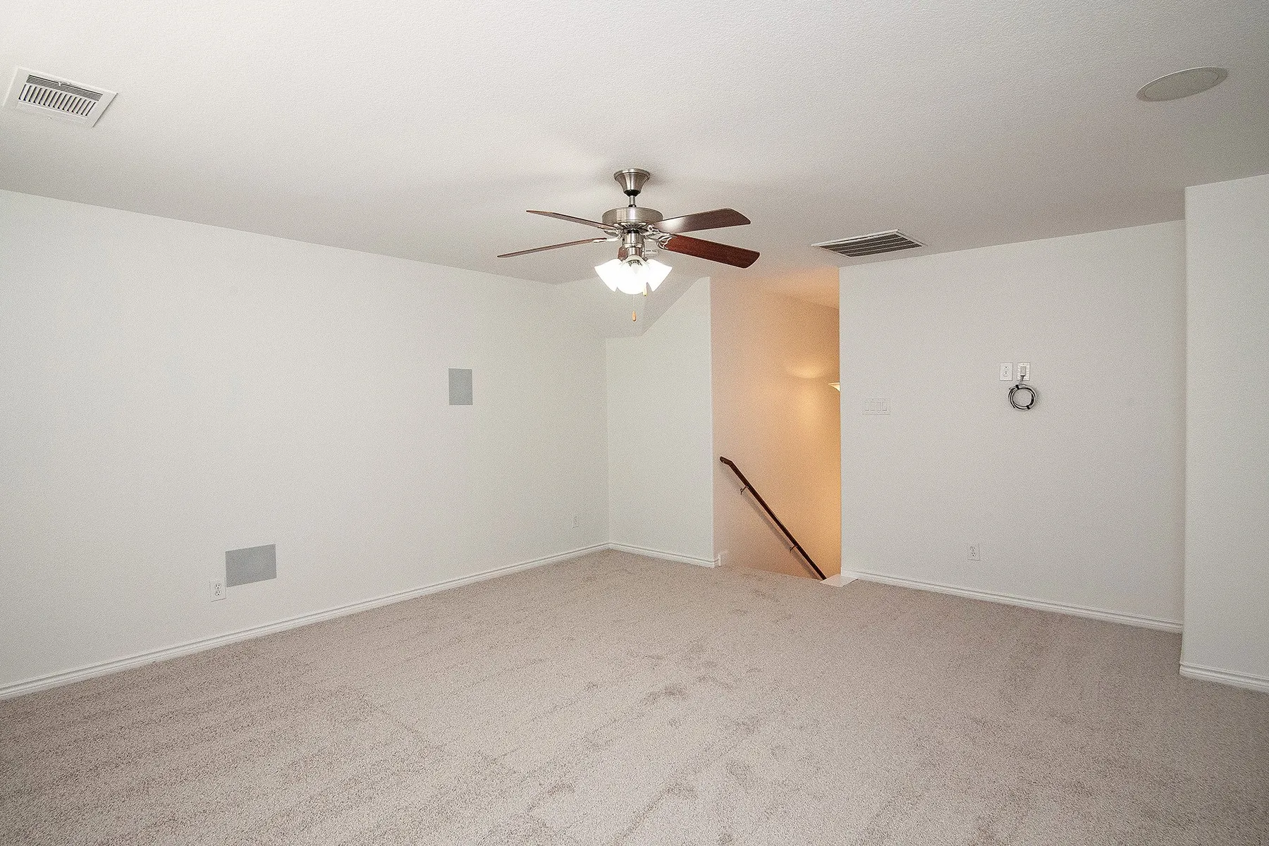 Spacious room featuring neutral carpeting, recessed lighting, and a ceiling fan with integrated light fixture