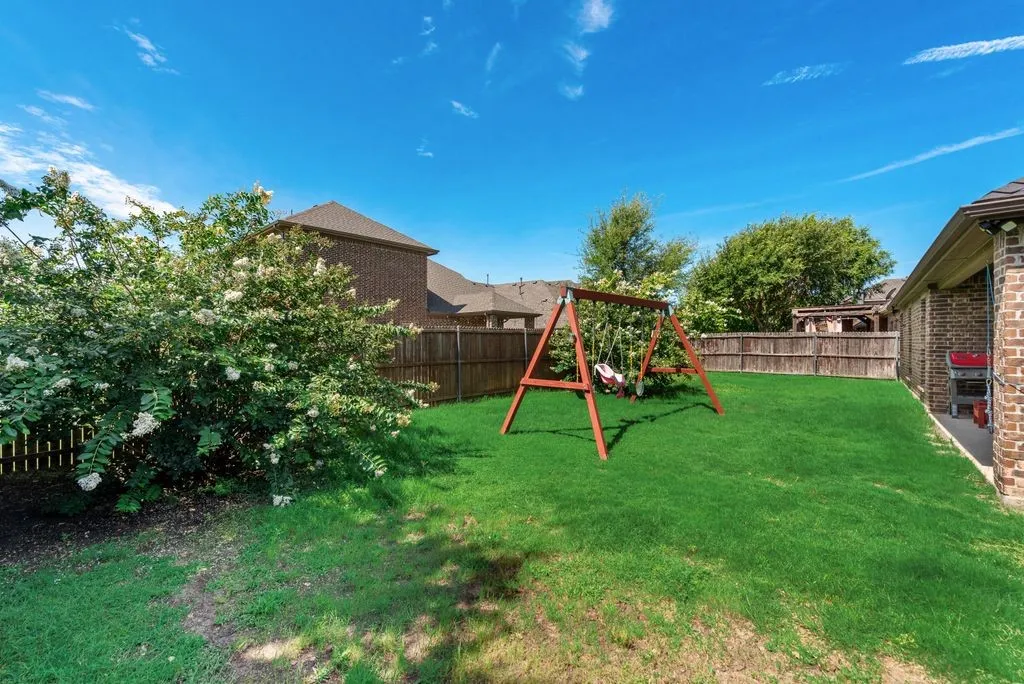 Expansive green lawn surrounded by wood fencing