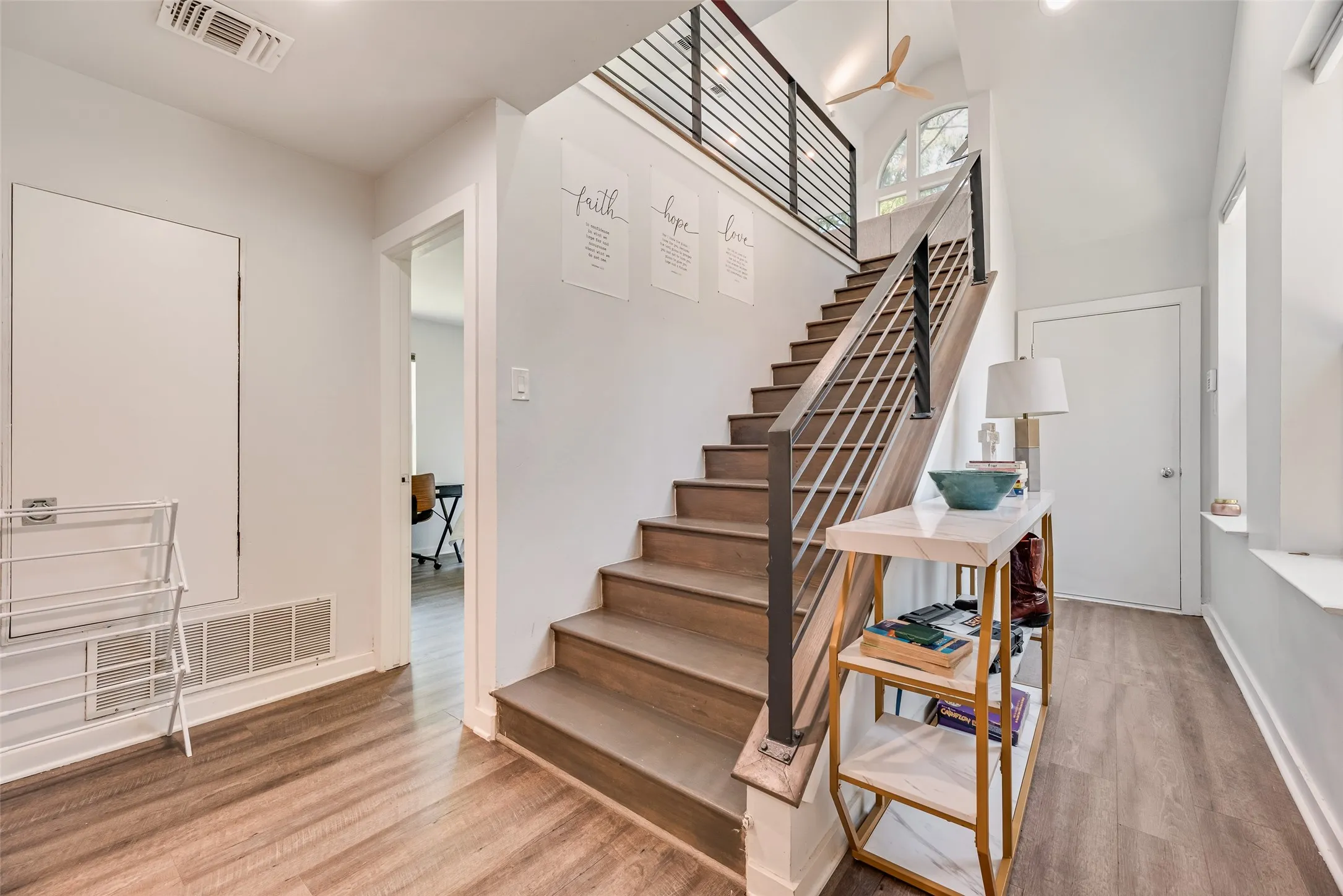Modern staircase featuring wood-finish treads and risers with an iron and wood-finish railing