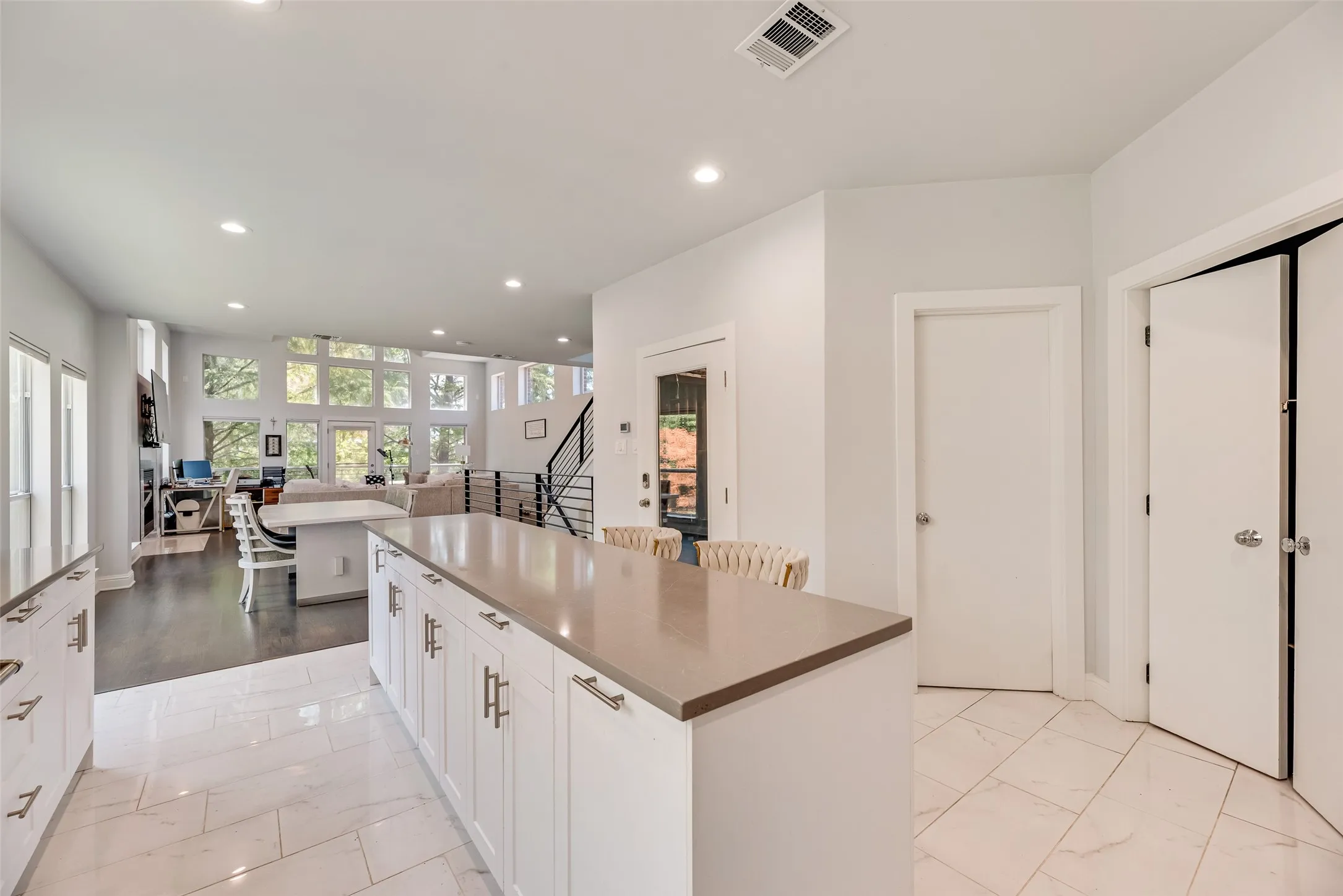 Gourmet kitchen island with stone countertop, white shaker cabinetry, and polished hardware