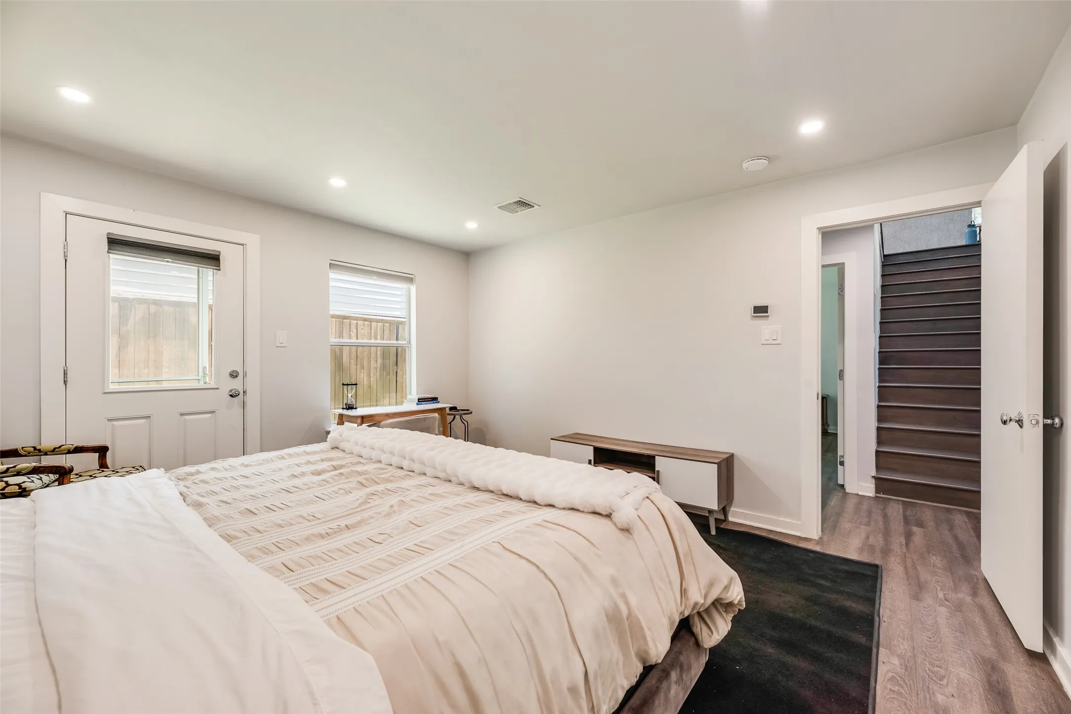 Spacious room featuring wood-finish flooring, recessed lighting, and a neutral color palette