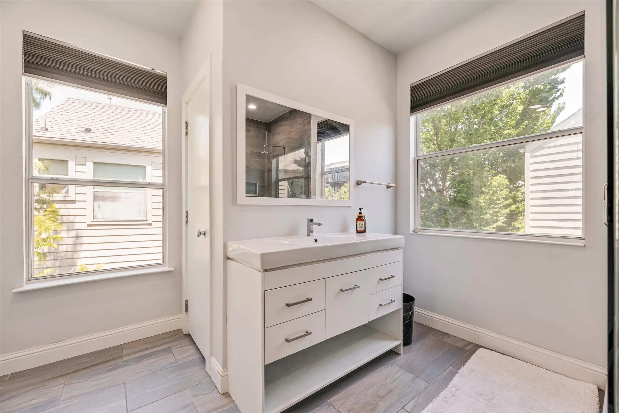 Bathroom featuring a white vanity with integrated sink, chrome faucet, and ample storage