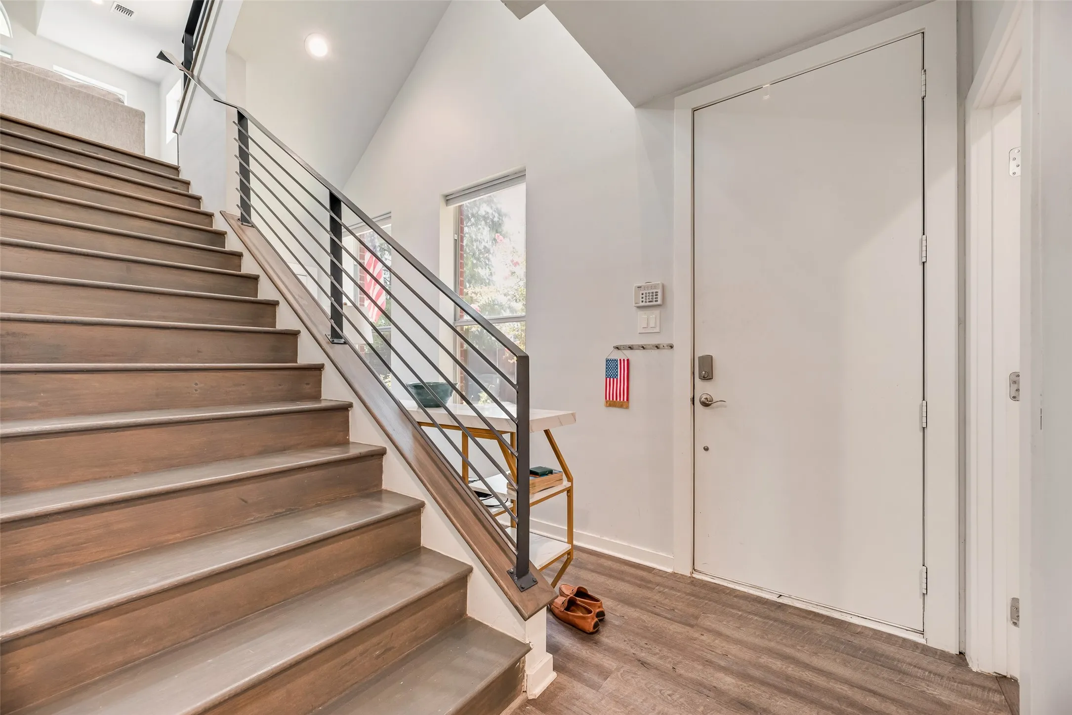 Modern staircase with wood-finish treads and risers, complemented by a contemporary metal railing