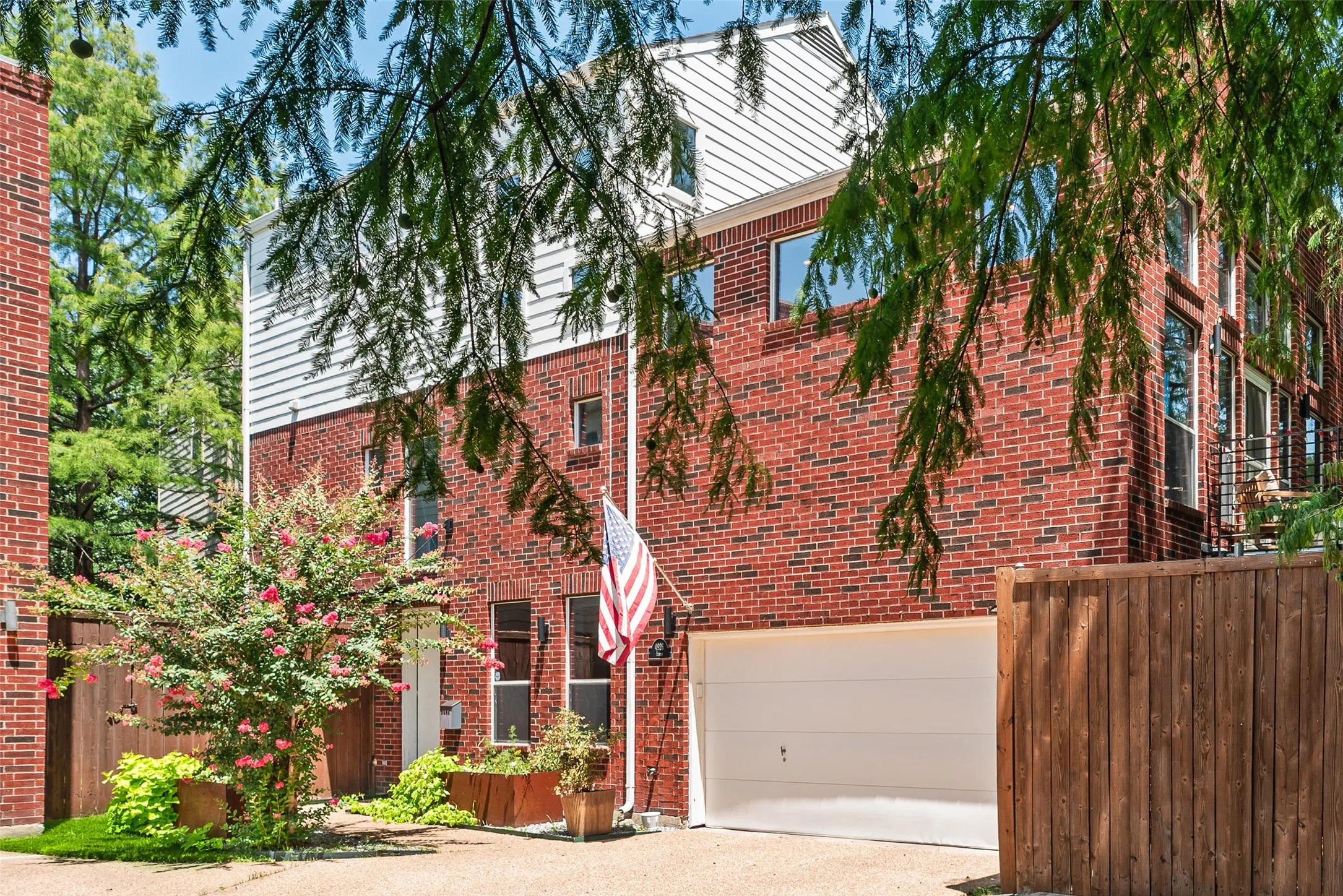 Brick facade with white siding accents and multiple windows