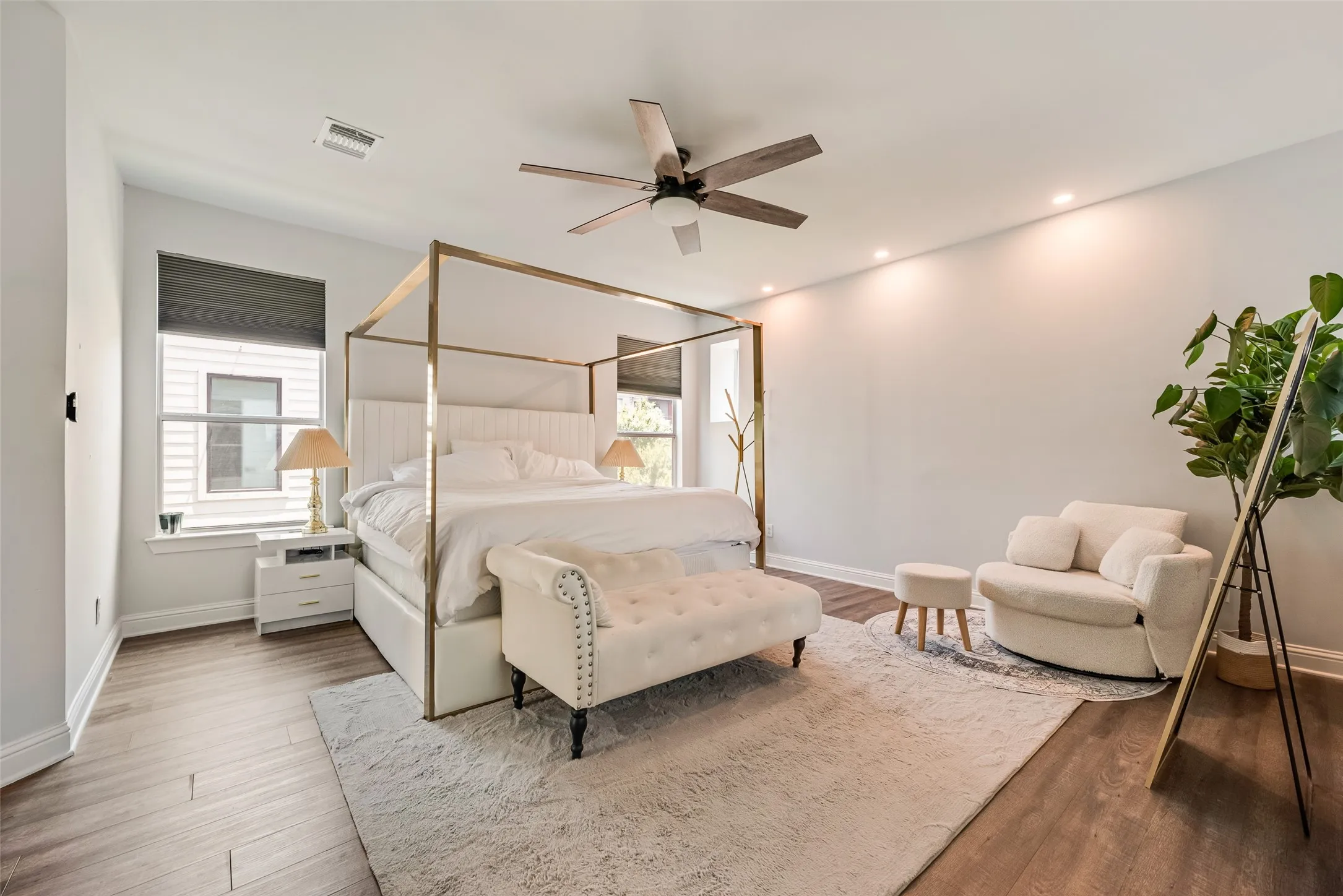 Spacious bedroom featuring wood-finish flooring, recessed lighting, and a ceiling fan