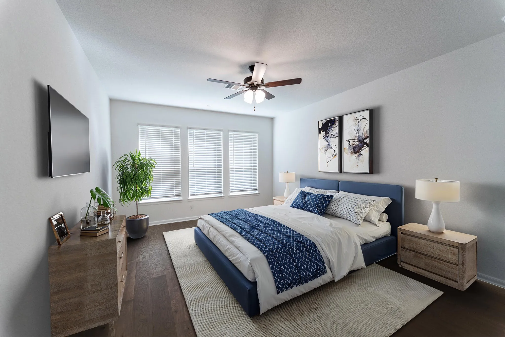 Bedroom featuring wood-finish flooring, a ceiling fan, three windows with blinds, a wall-mounted television, and neutral-toned walls