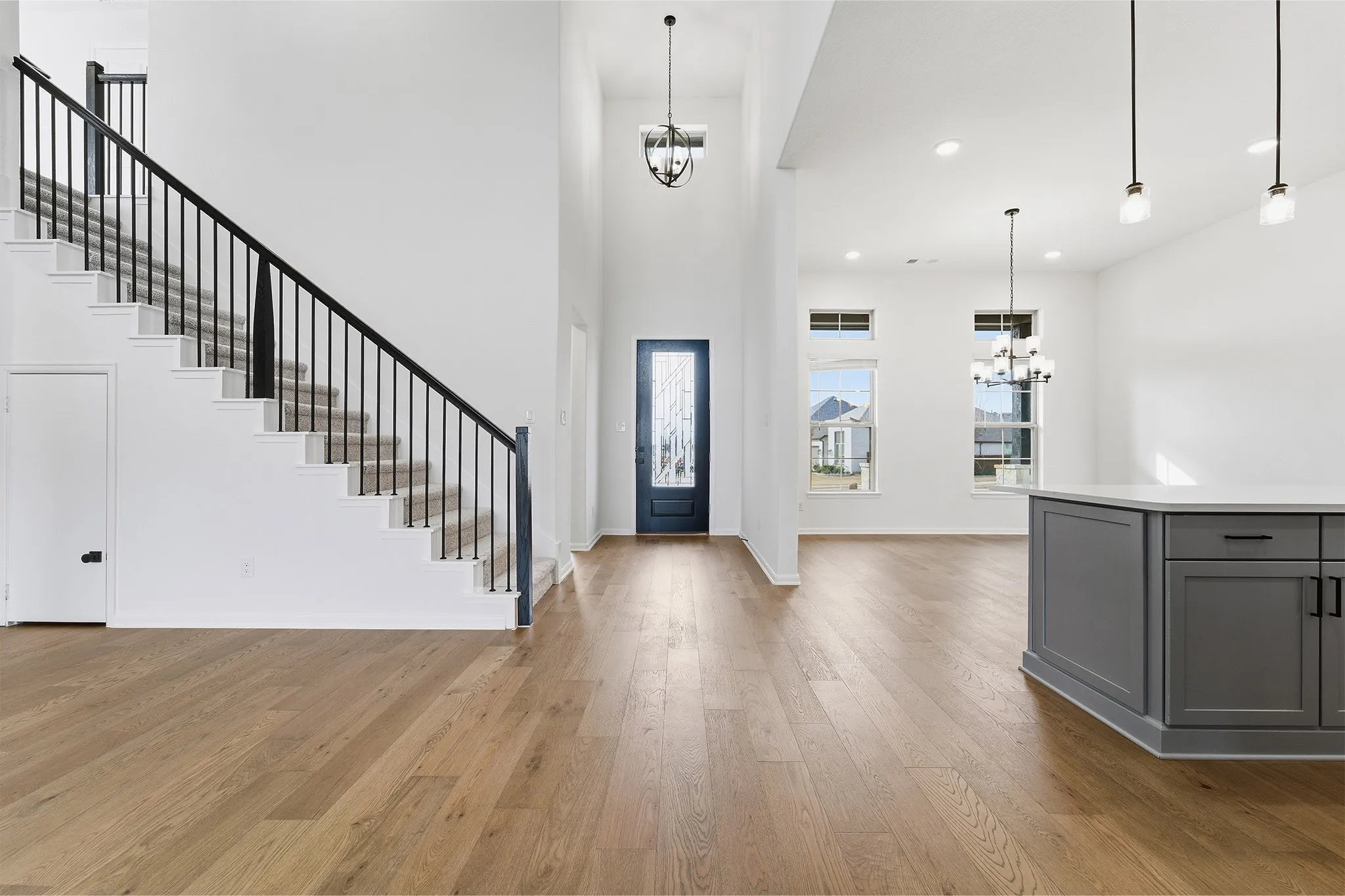 Entryway with a two-story ceiling, wood-finish flooring, and a dark stained front door