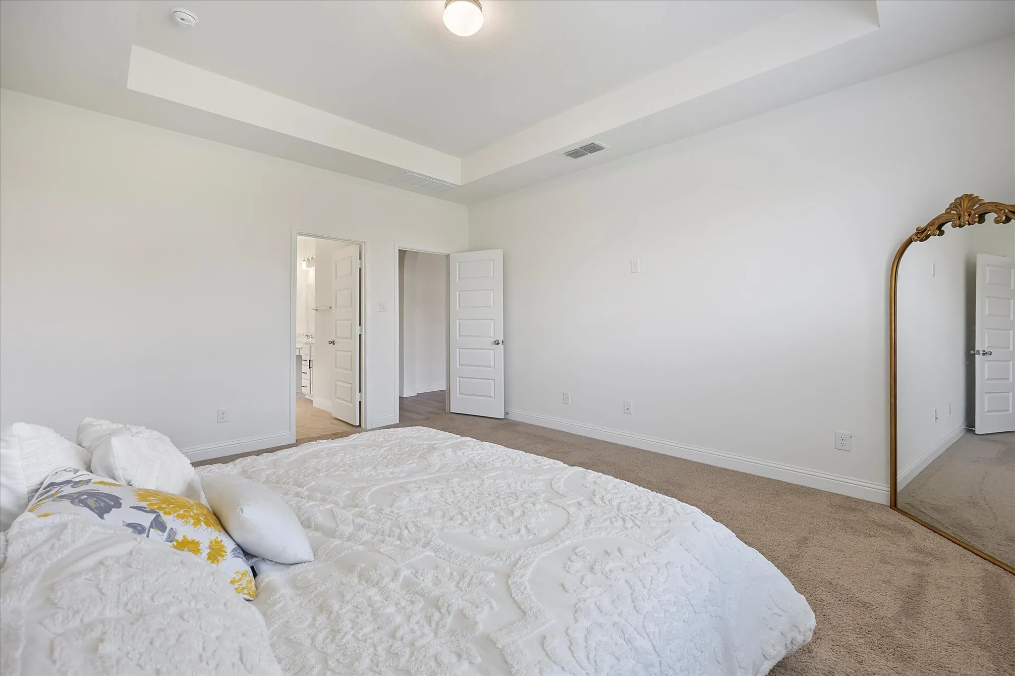 Master bedroom features tiered ceiling and room for sitting area
