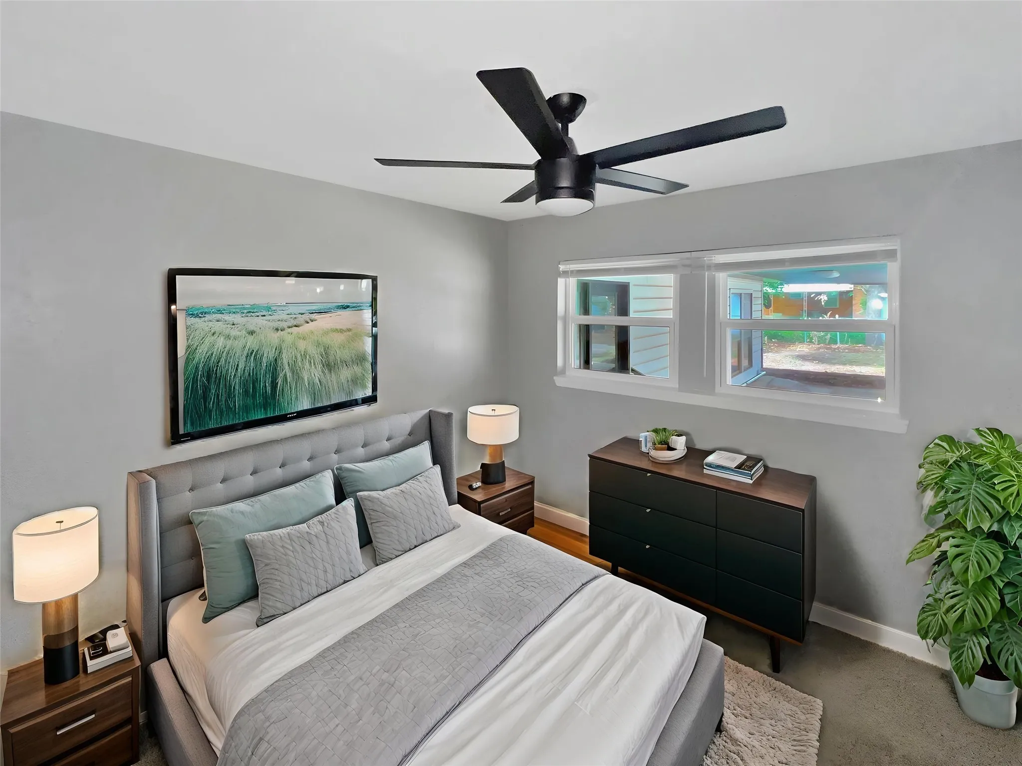 Virtually staged
Bedroom featuring a modern ceiling fan, two windows, and light gray wall paint