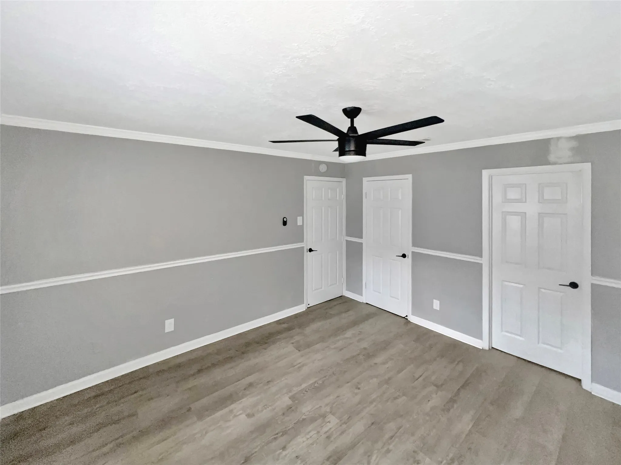 Room featuring wood-finish flooring and a contemporary black ceiling fan