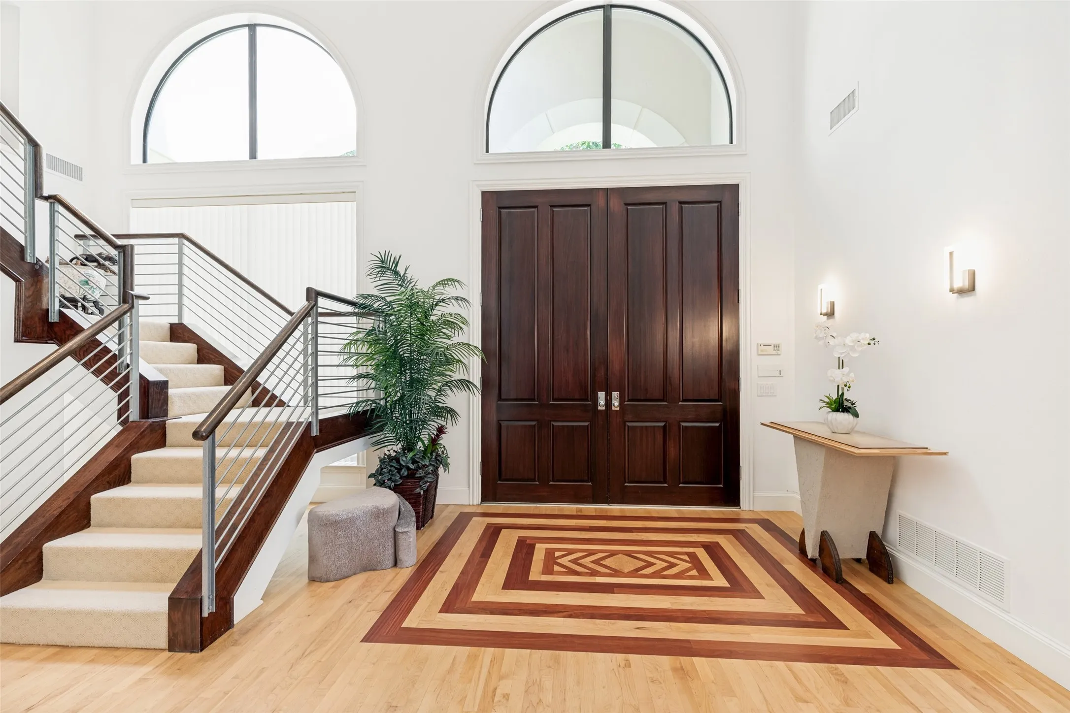 Grand entry foyer featuring a striking inlaid wood floor design