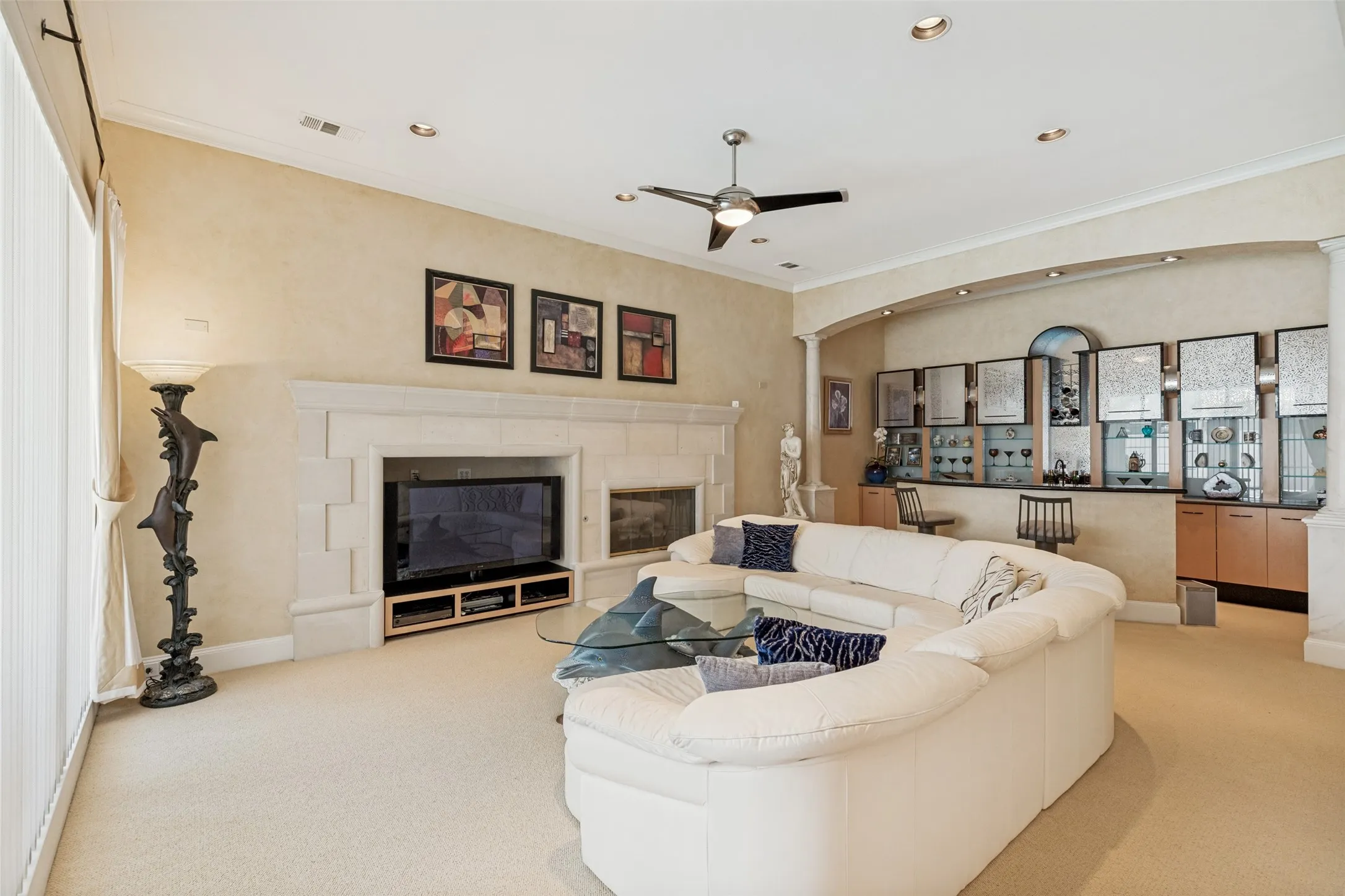 Spacious living area featuring a built-in entertainment center with a stone fireplace, recessed lighting, and a ceiling fan