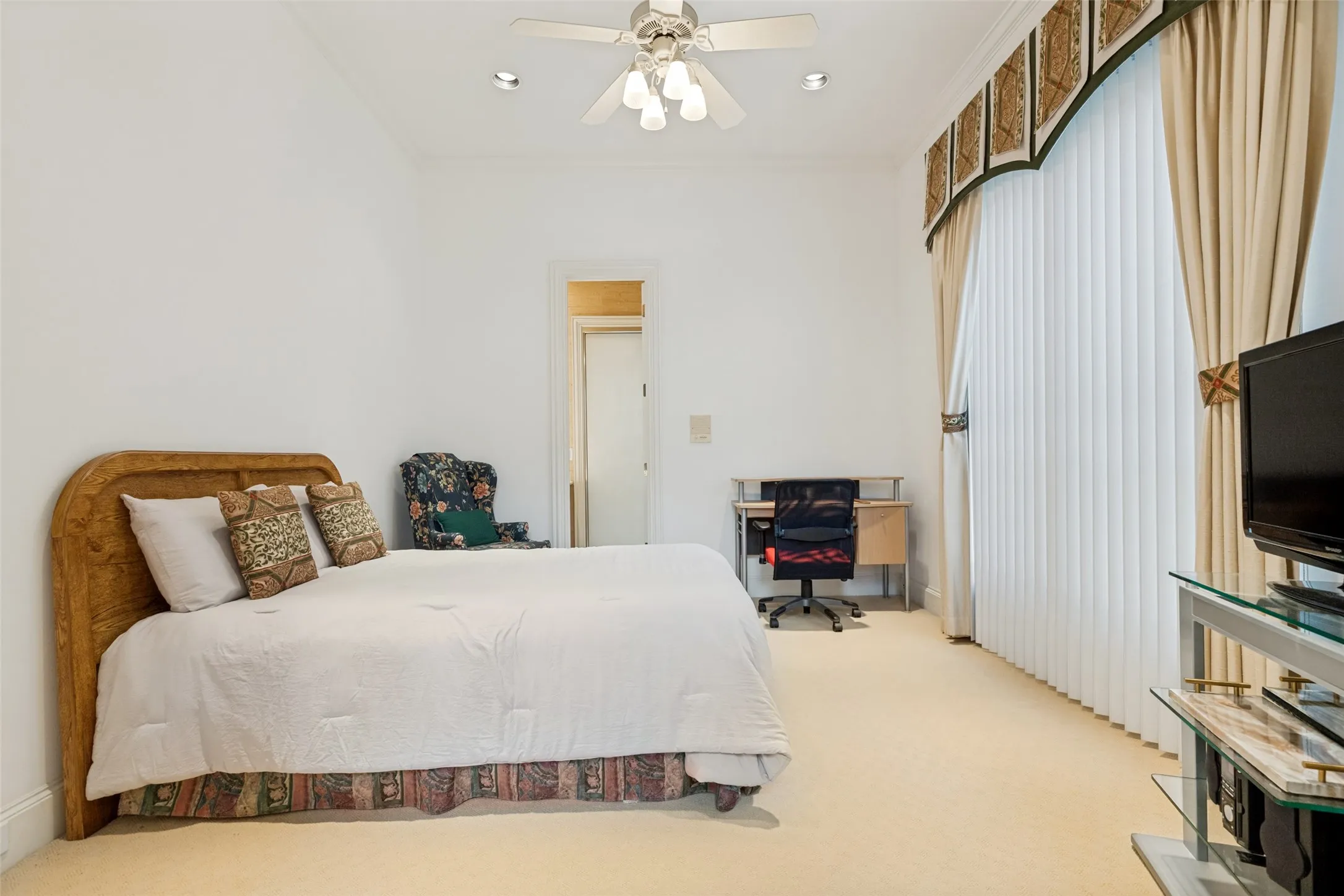 Expansive room featuring light-toned carpet flooring, a ceiling fan with integrated lighting, and recessed overhead lighting