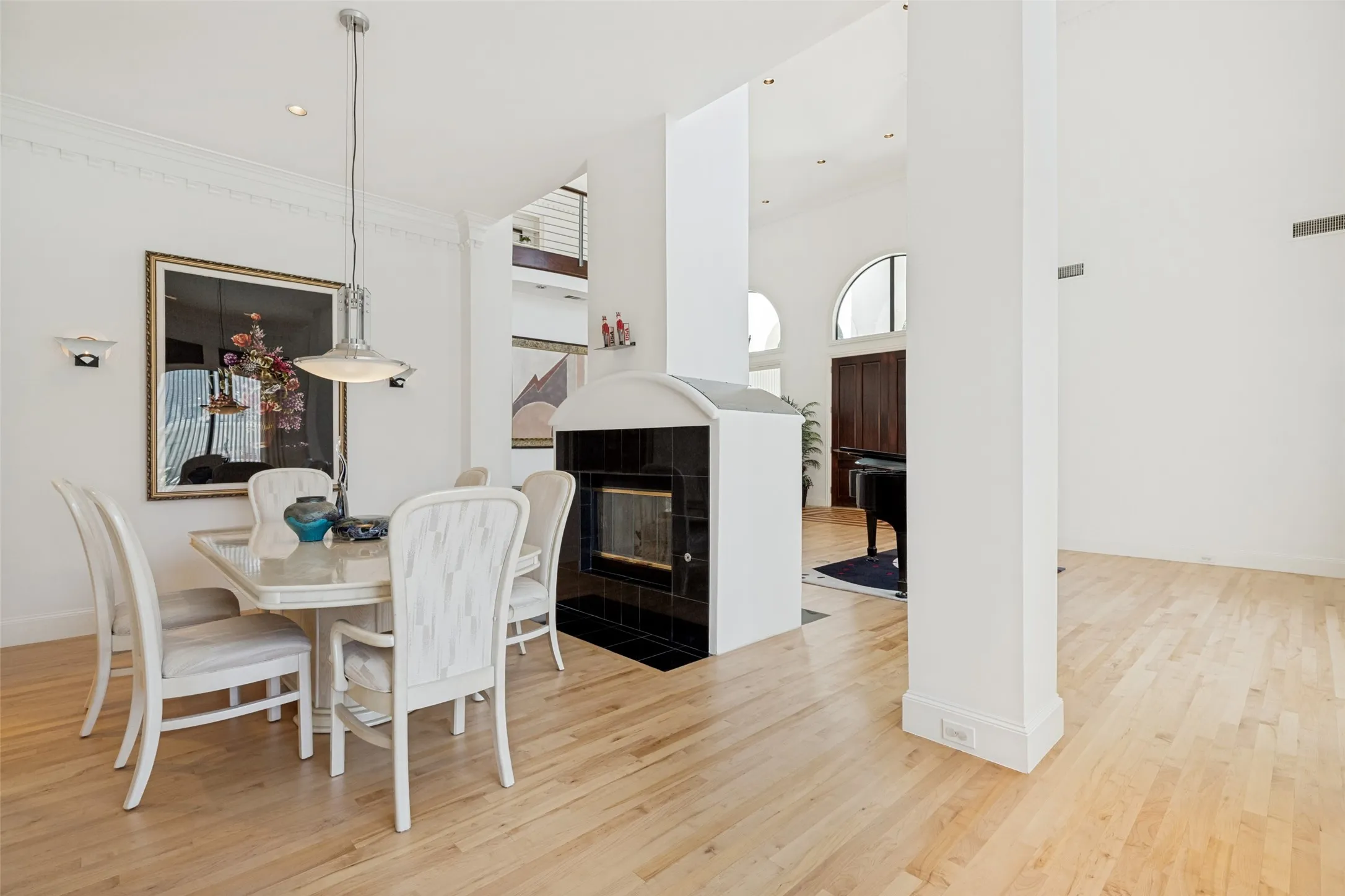 Light wood-finish flooring throughout, featuring a dining area with a contemporary pendant light fixture