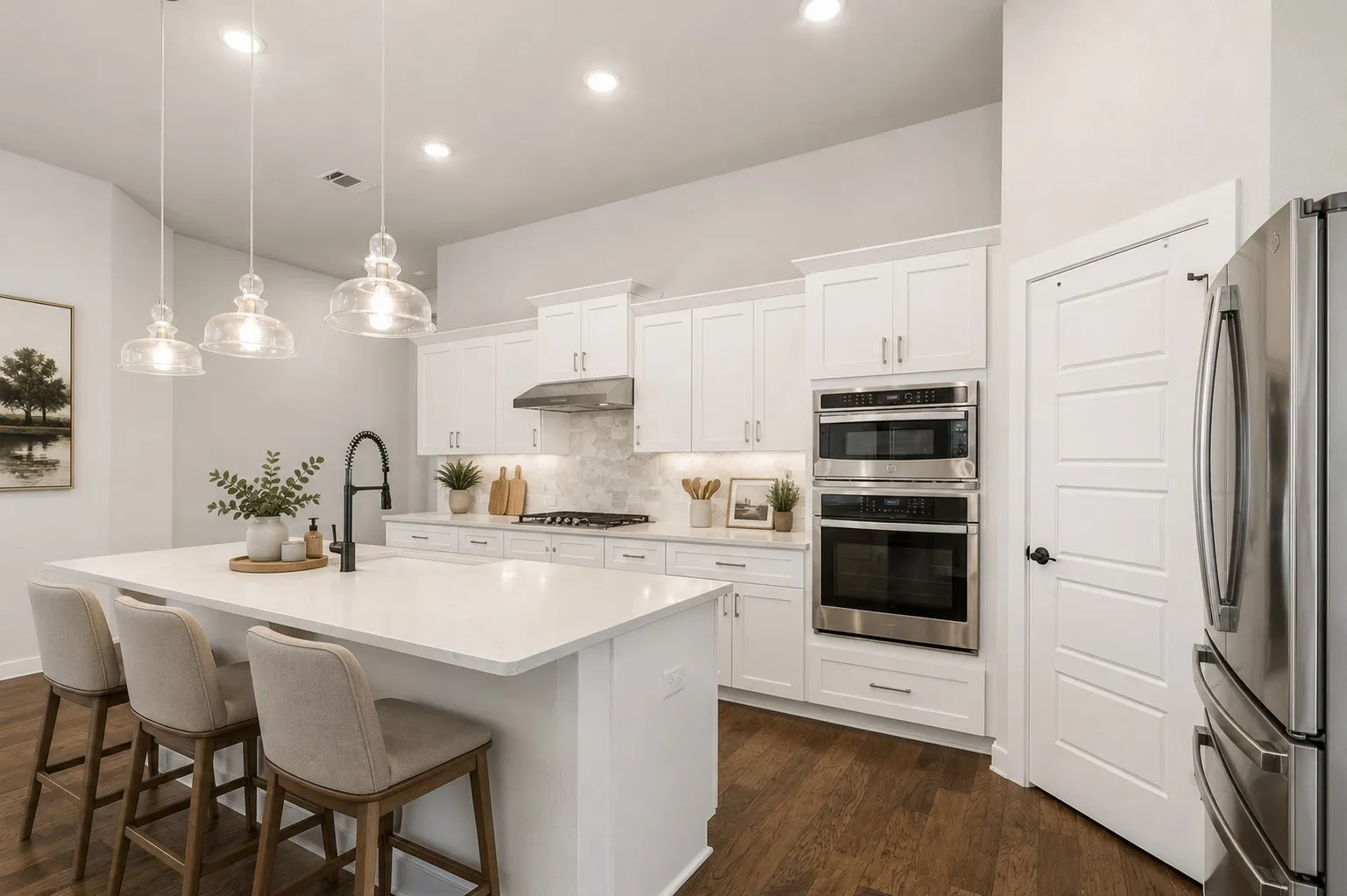 Kitchen featuring white cabinetry, stainless steel appliances including a double oven, a center island with pendant lighting, and wood-finish flooring