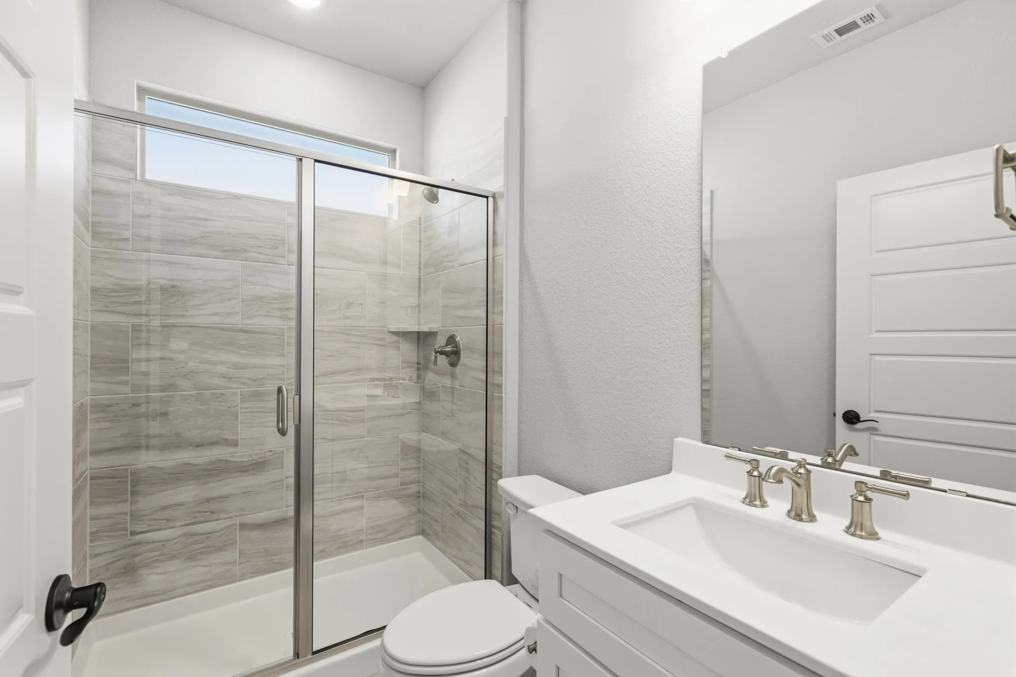 Glass-enclosed shower with a tiled surround and built-in shelf