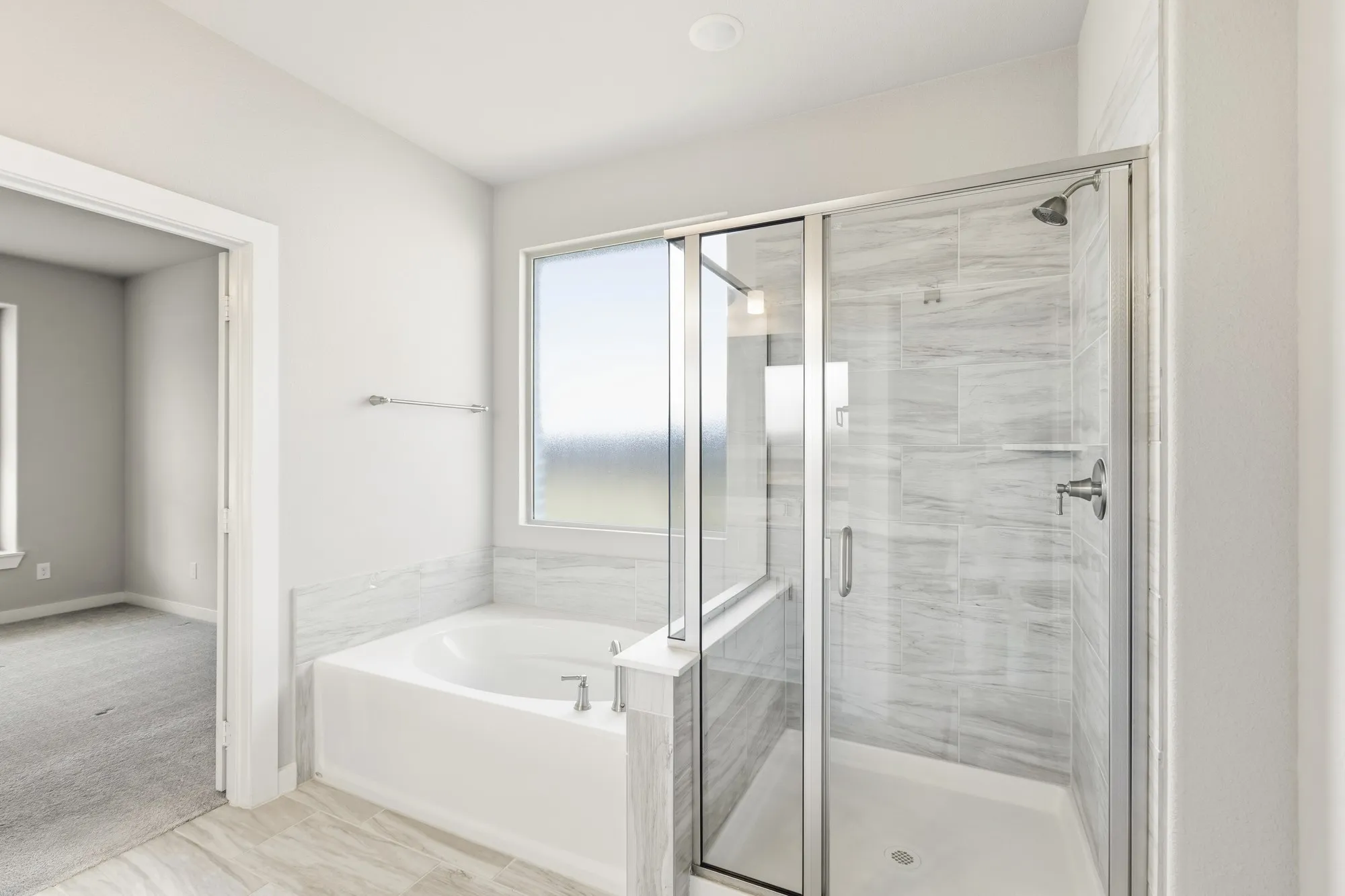 Bathroom featuring a glass-enclosed shower with tile surround, a built-in bathtub, a window, and light-toned tile flooring