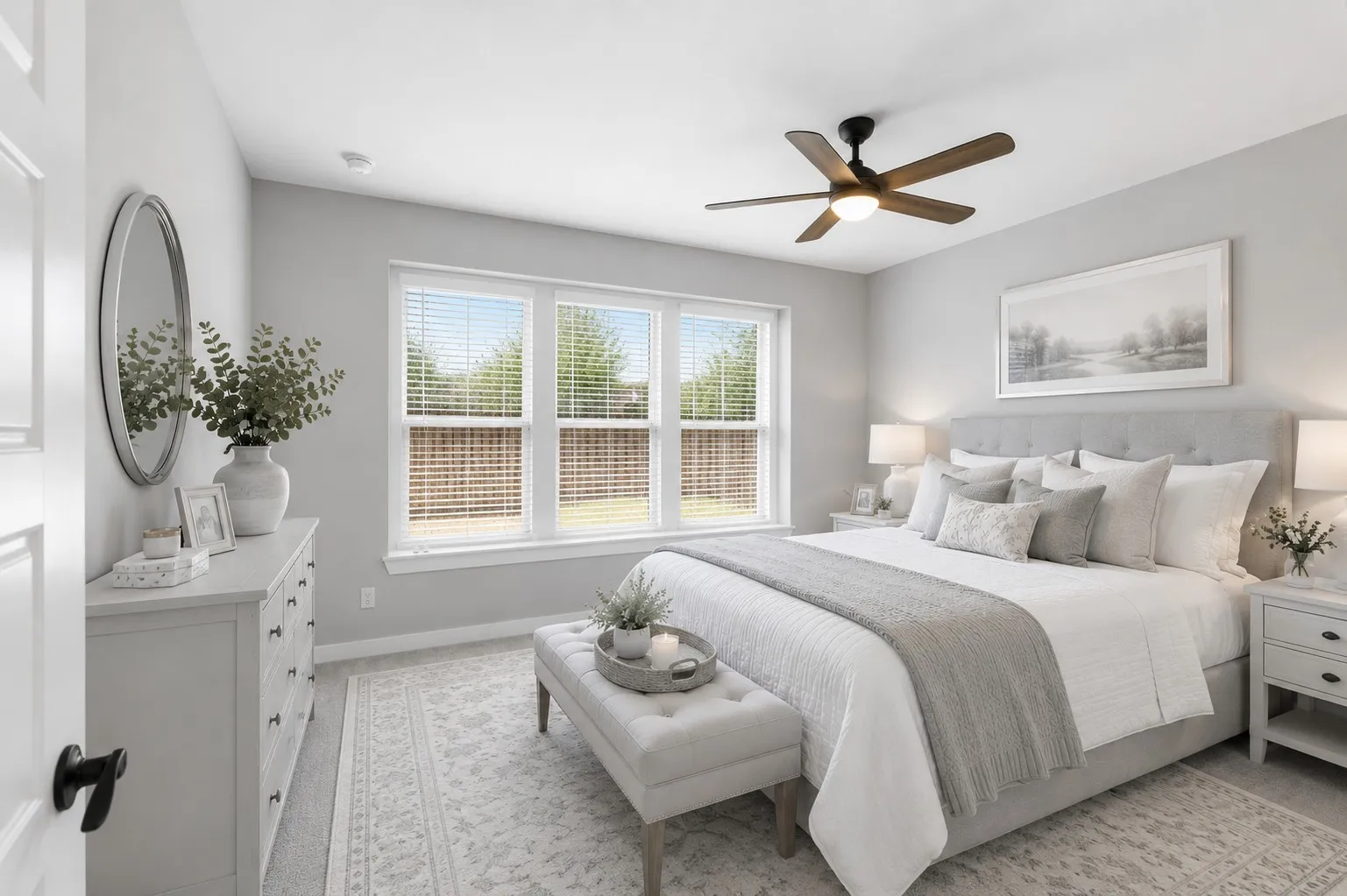 Bright bedroom featuring multiple windows, a ceiling fan with integrated lighting, soft gray walls, and light-colored carpeting
