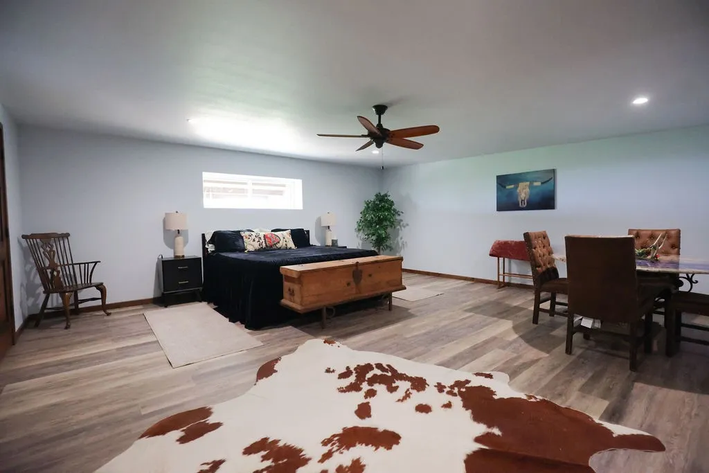 Oversized bedroom with room for a king bed and a separate sitting or dining area. Luxury vinyl plank floors, a ceiling fan and a window for natural light make it ideal as a guest suite or primary retreat.