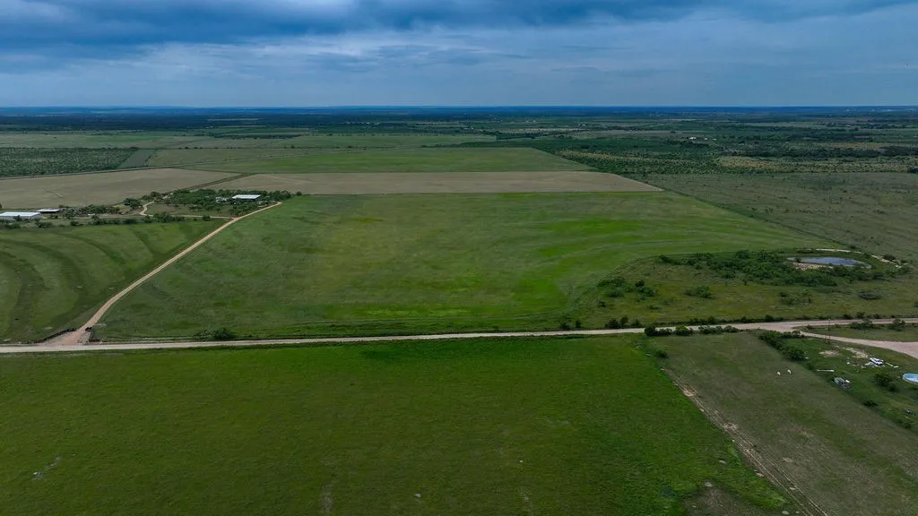 Ranch overview showing hay fields, open pasture, county road frontage, the stock tank and the homestead. It gives a full picture of the 283.98 acres.