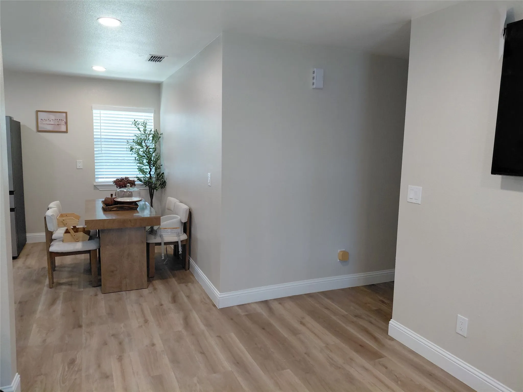 Dining area featuring wood-finish flooring, recessed lighting, and a window with blinds