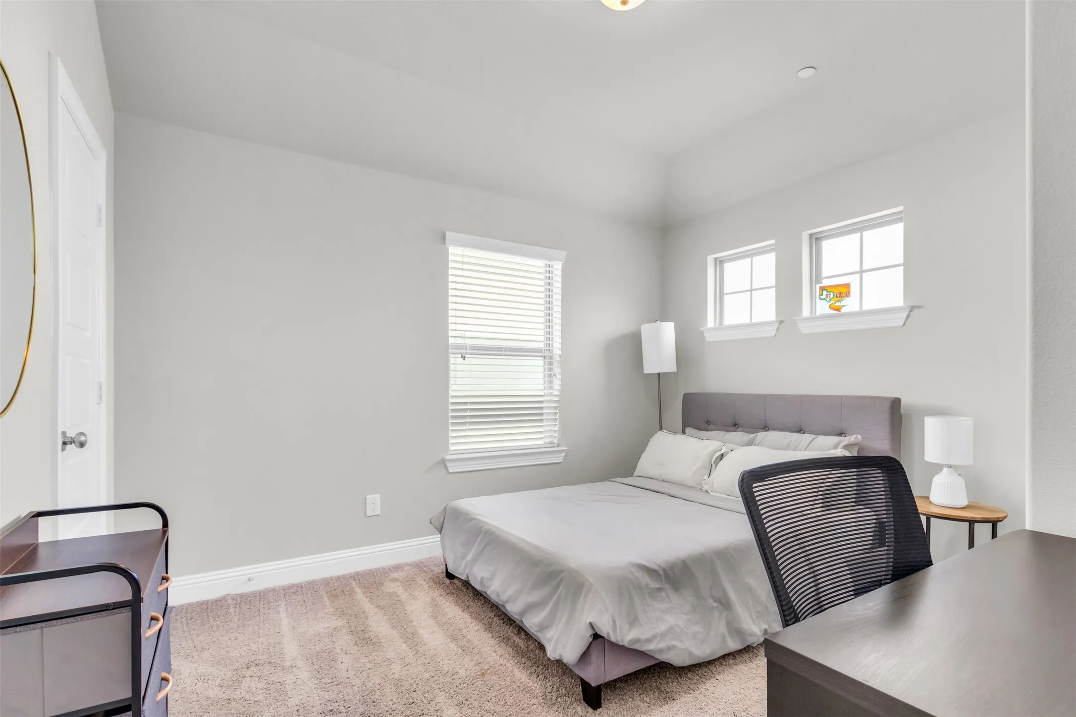 Carpeted room featuring light gray walls, white trim, and a high ceiling