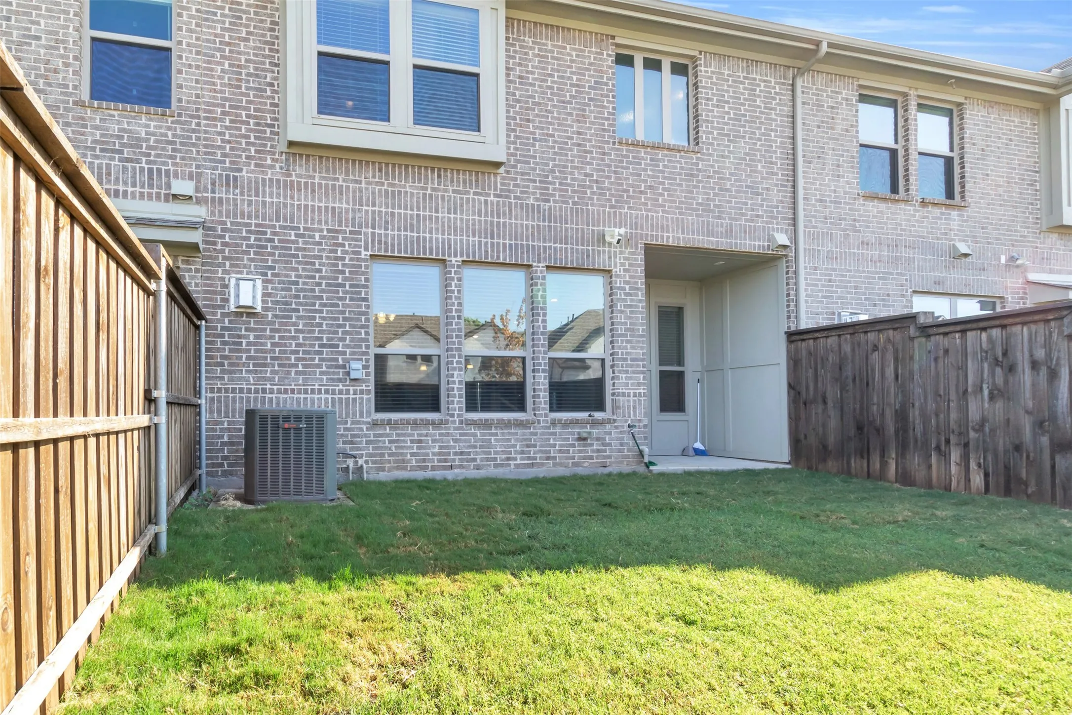 Private backyard space featuring a brick exterior and a privacy fence