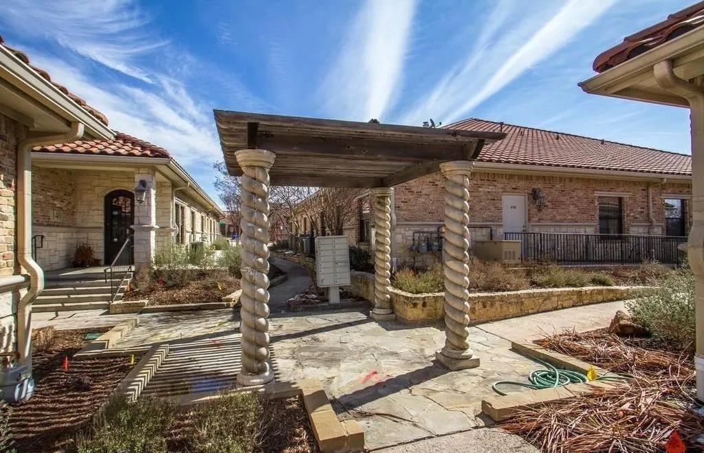 Central stone pergola with spiral columns and a wood-beam top