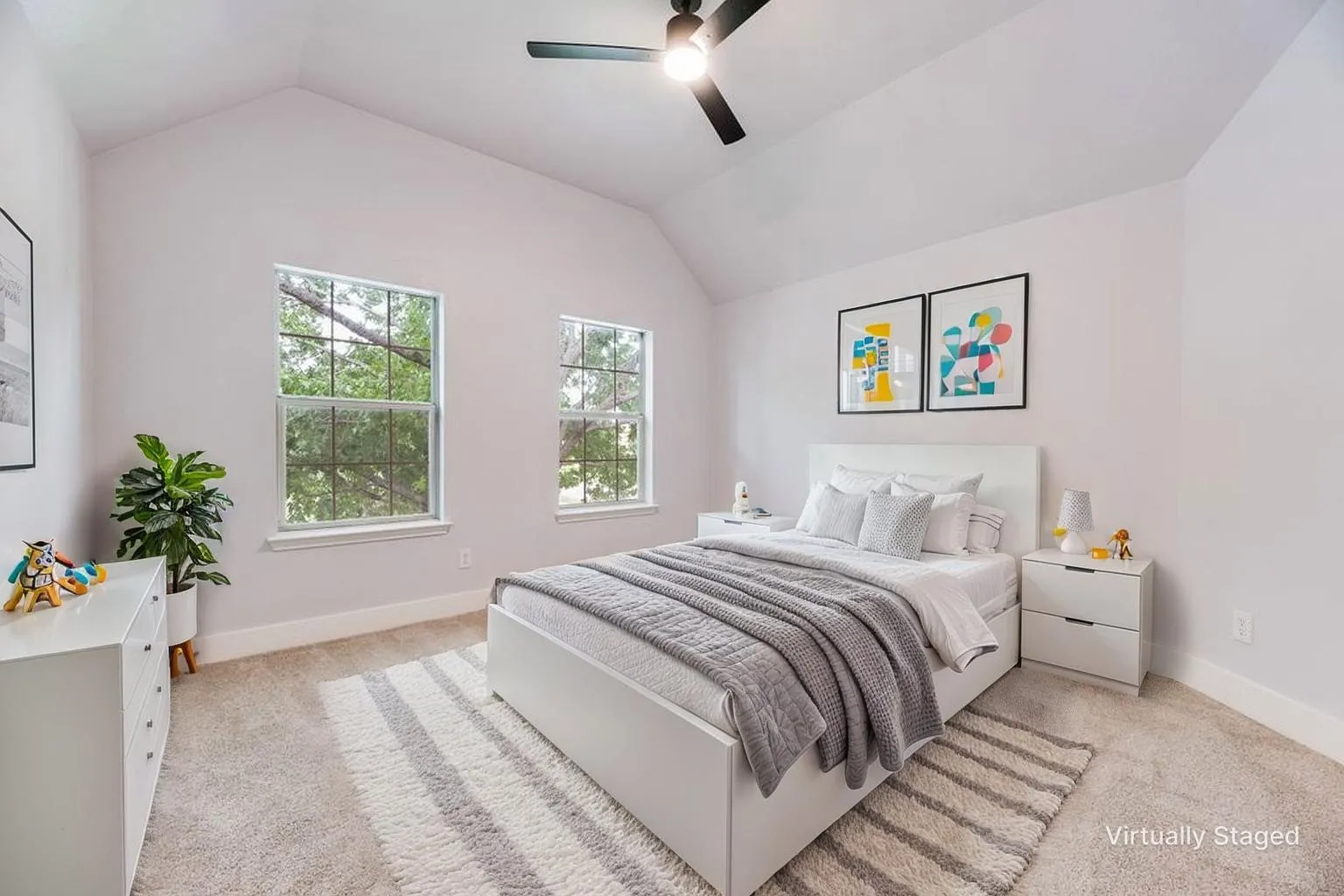 Vaulted ceiling, two windows, ceiling fan, and light-colored carpeting