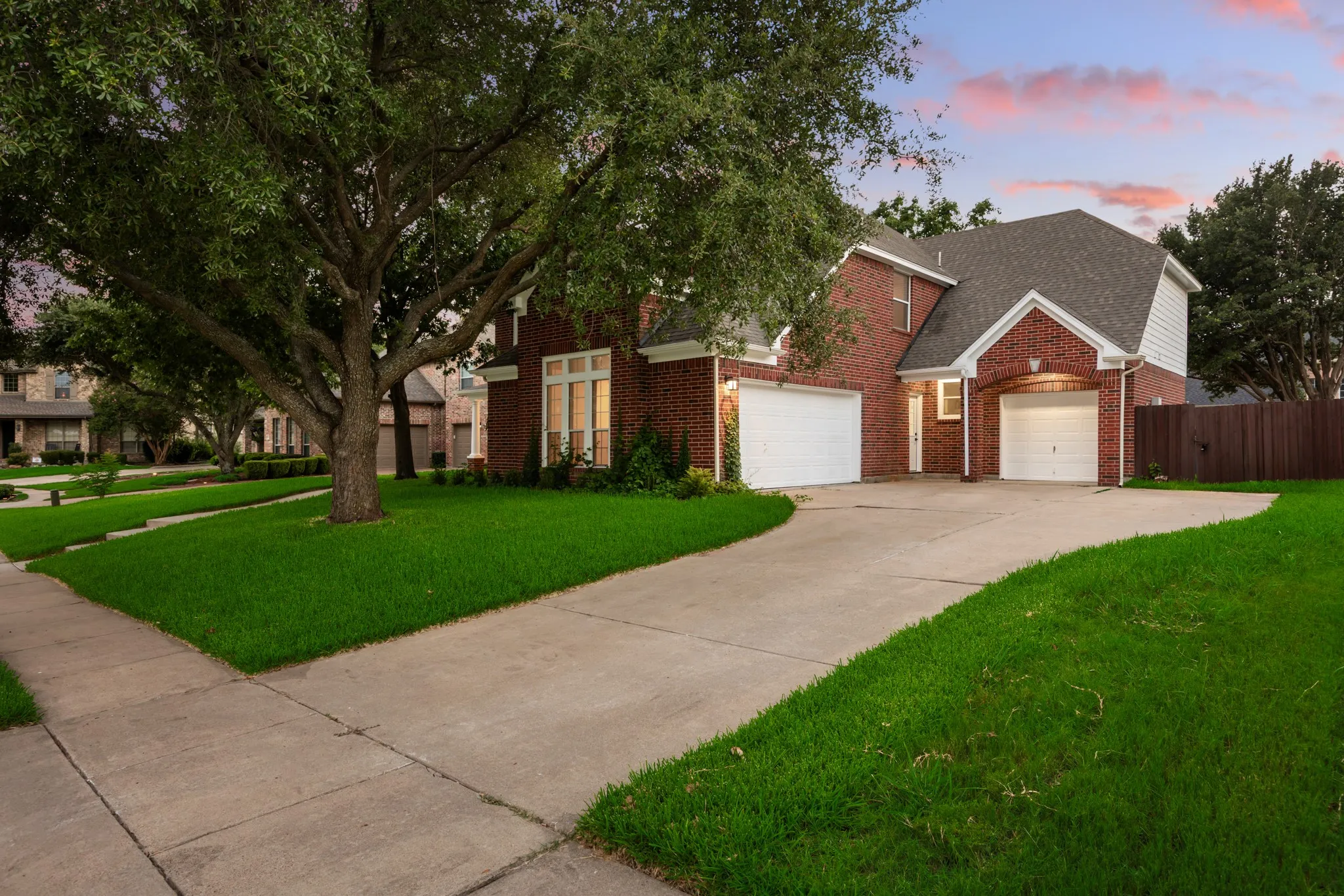 Brick exterior residence featuring a two-car garage, an additional single-car garage, and a concrete driveway