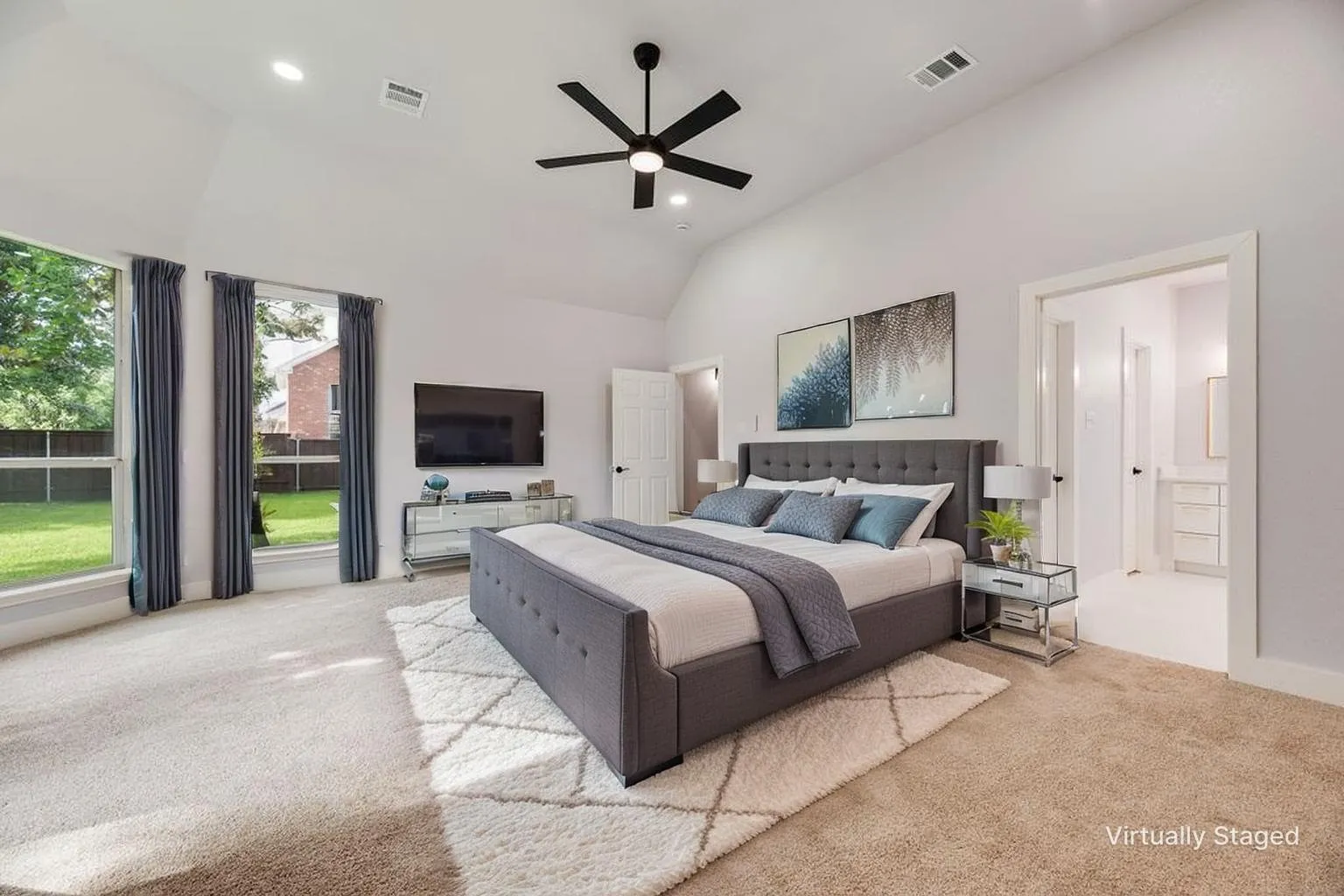 Vaulted ceilings with recessed lighting, large windows, ceiling fan, and carpeted flooring