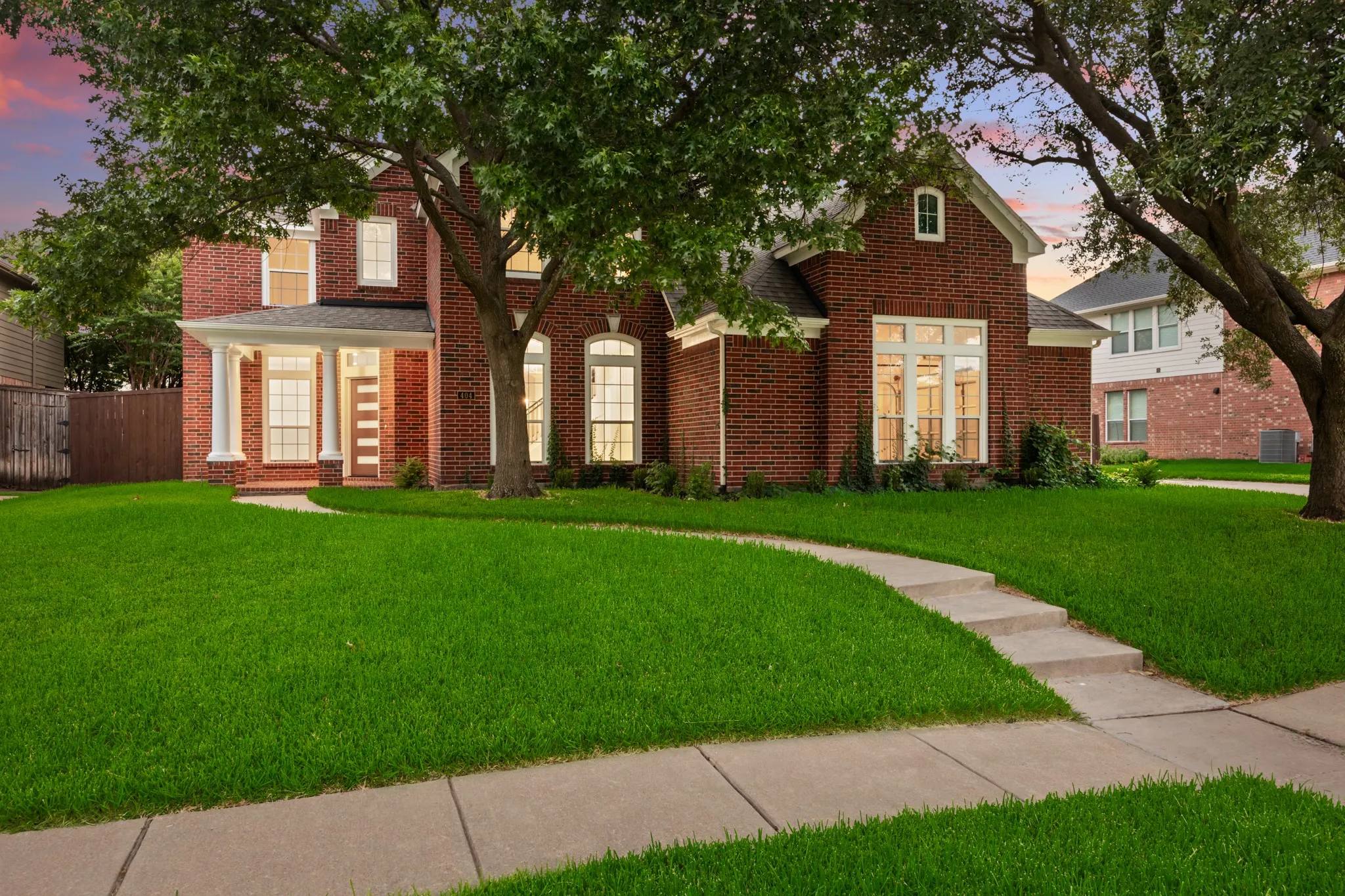 Traditional brick exterior featuring a covered entry with white columns