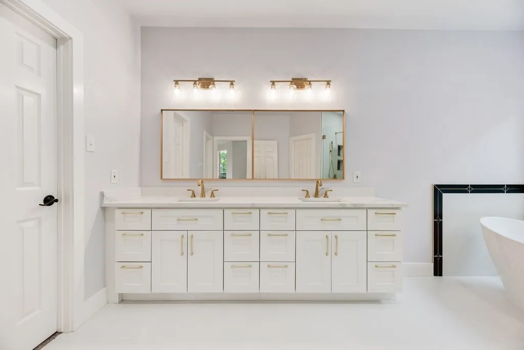 Indulge in the spa-inspired primary bath featuring dual vanities, elegant gold fixtures