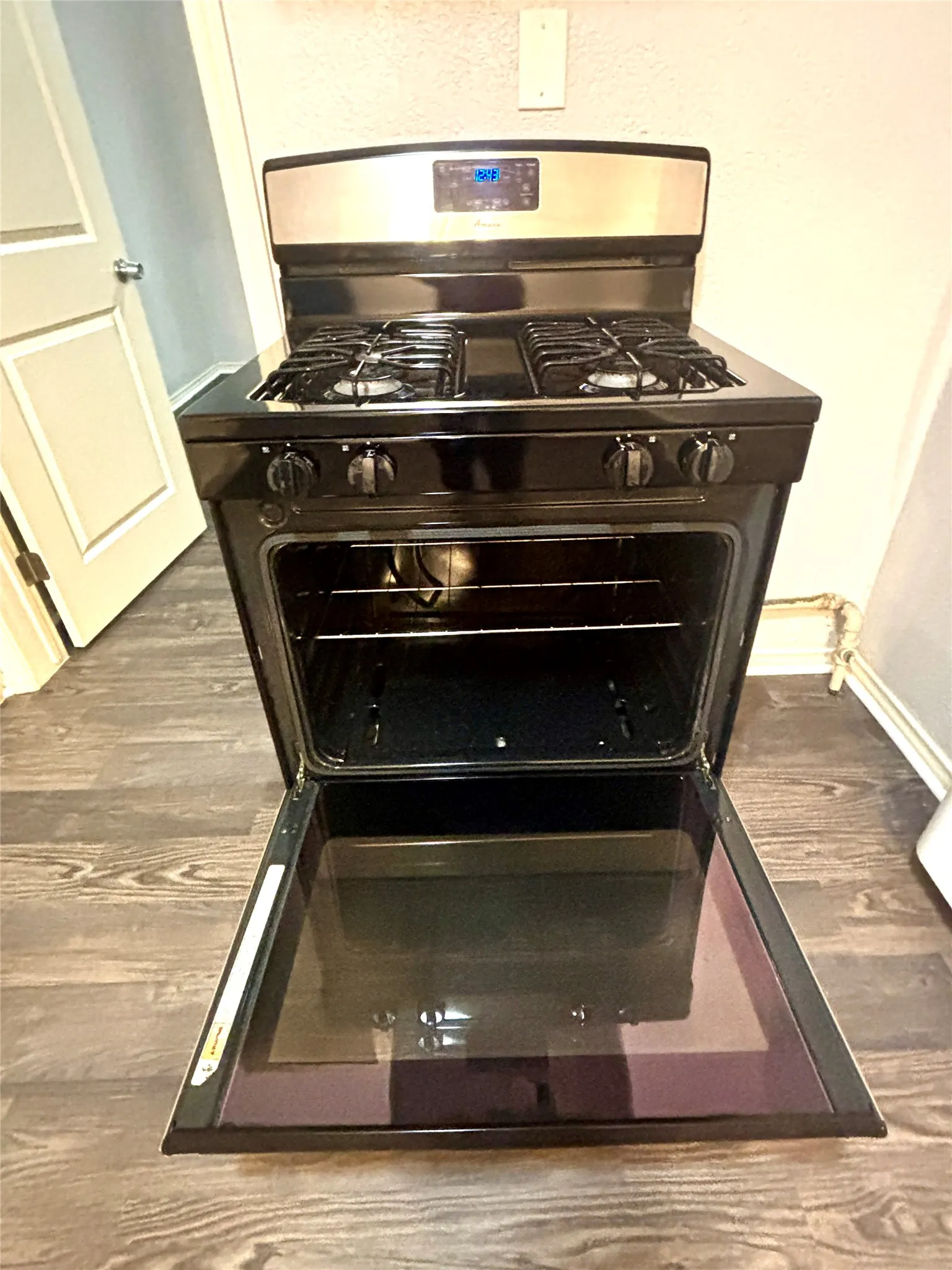 Stainless steel and black range with four gas burners, digital display, and ample oven capacity