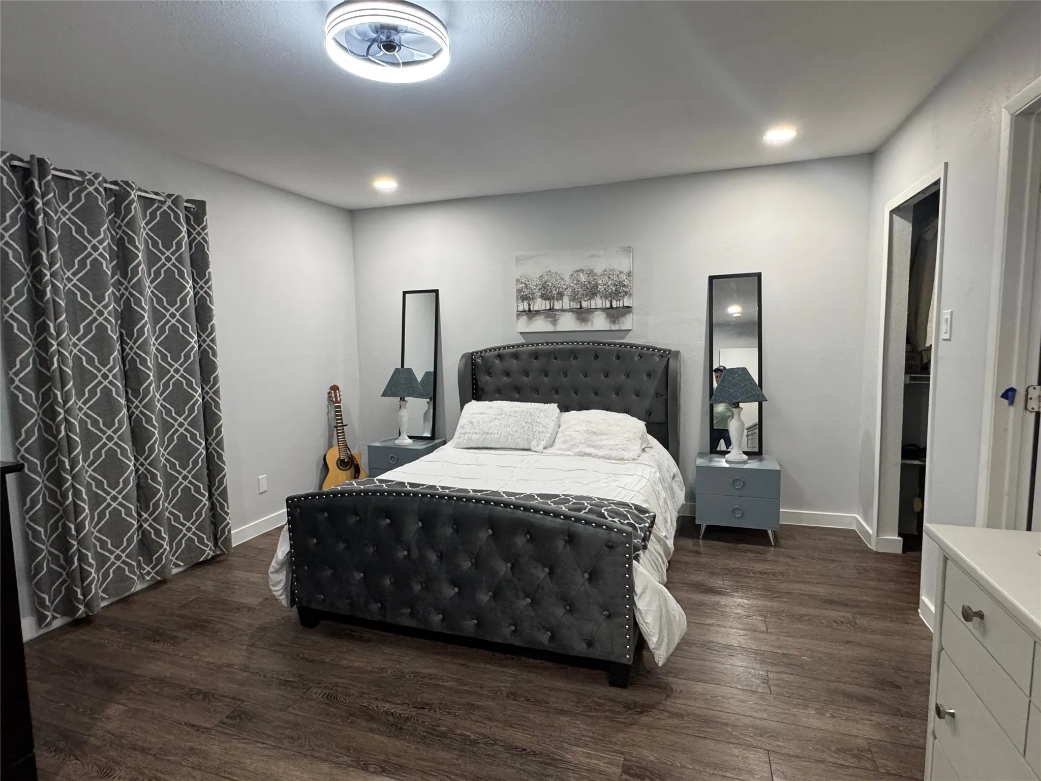 Spacious room featuring wood-finish flooring and light gray walls