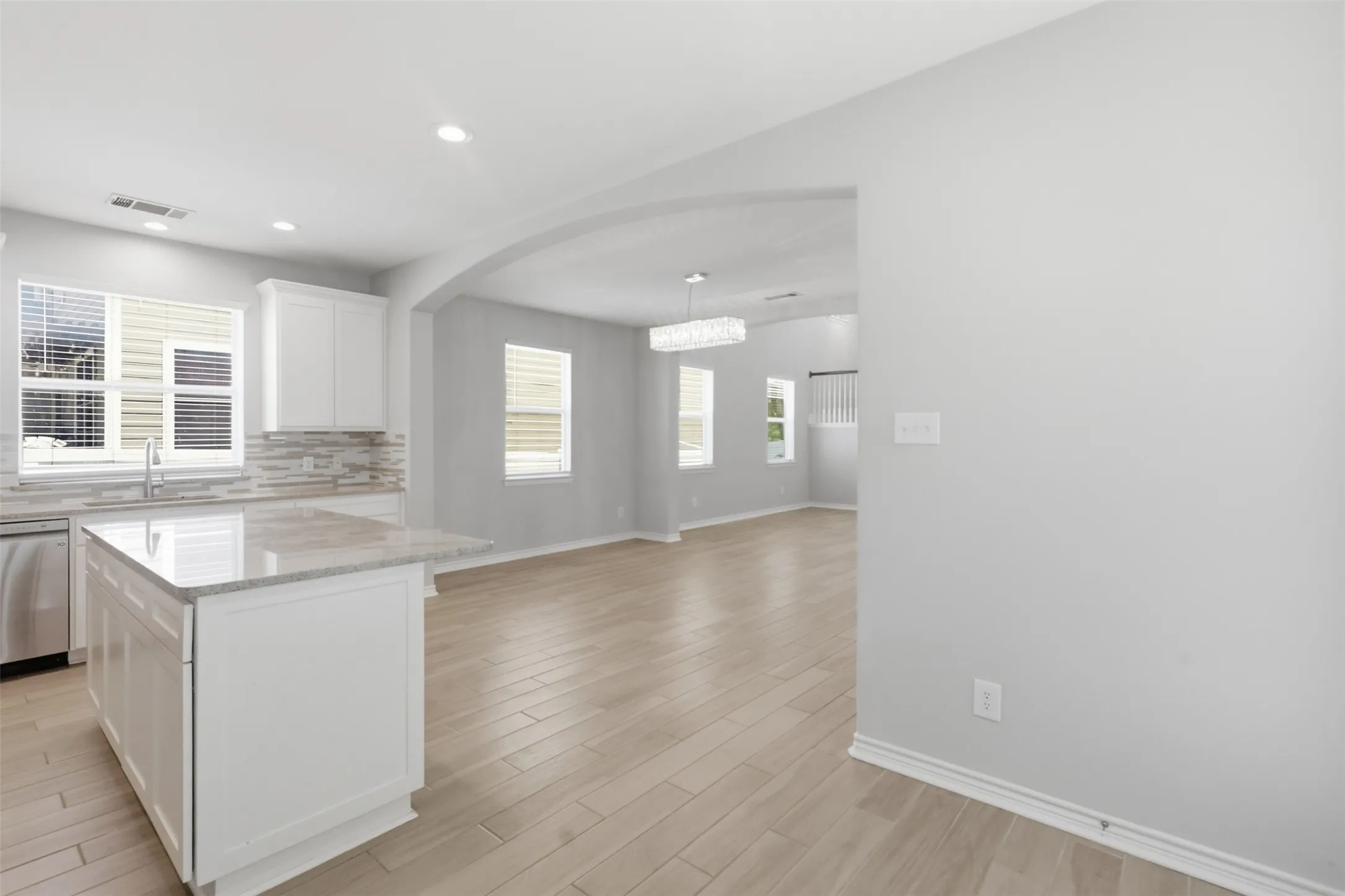 Modern kitchen featuring an island with a light-colored countertop, white cabinetry, and stainless steel appliances