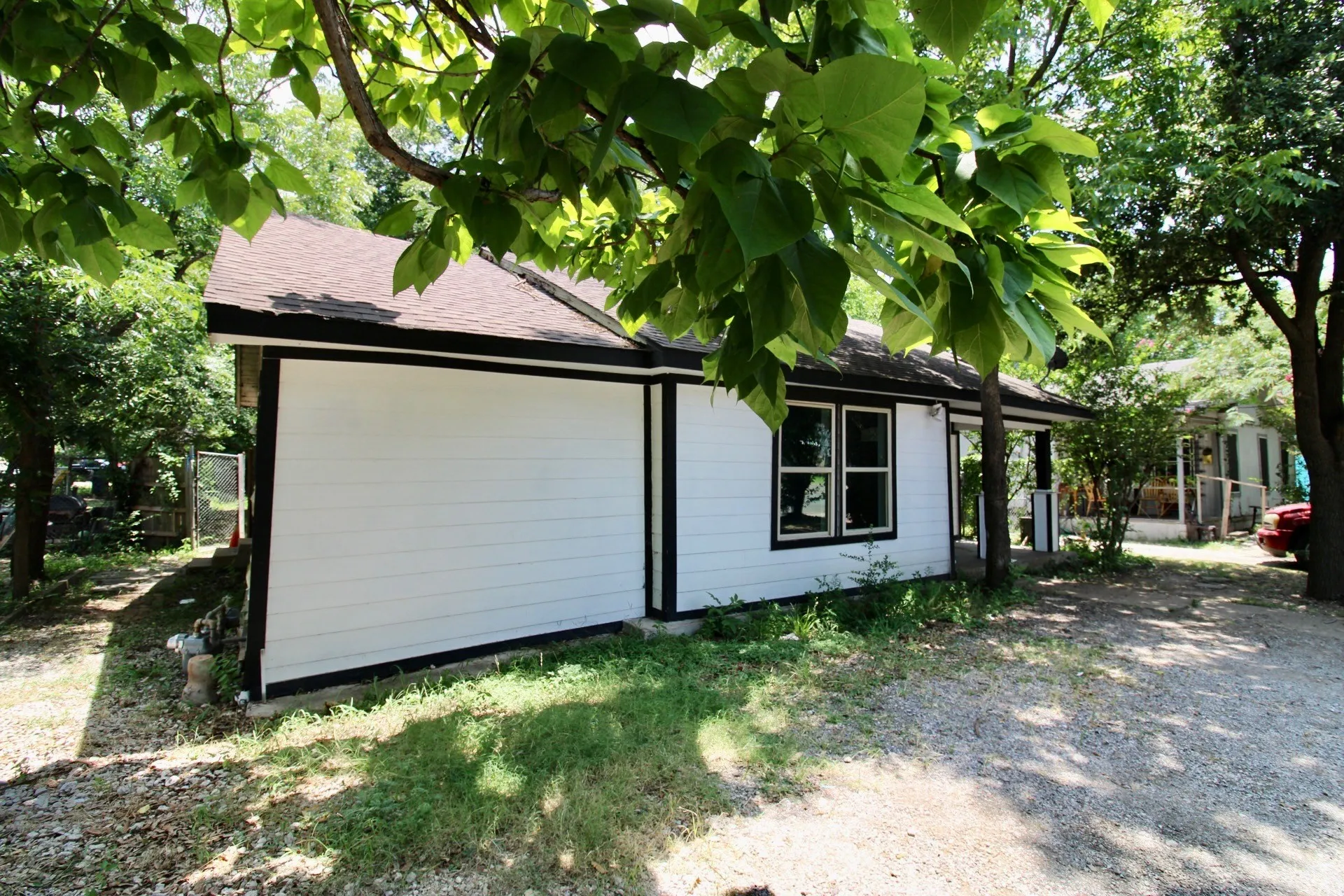 White siding exterior with black trim details, multi-pane windows, and a dark shingle roof