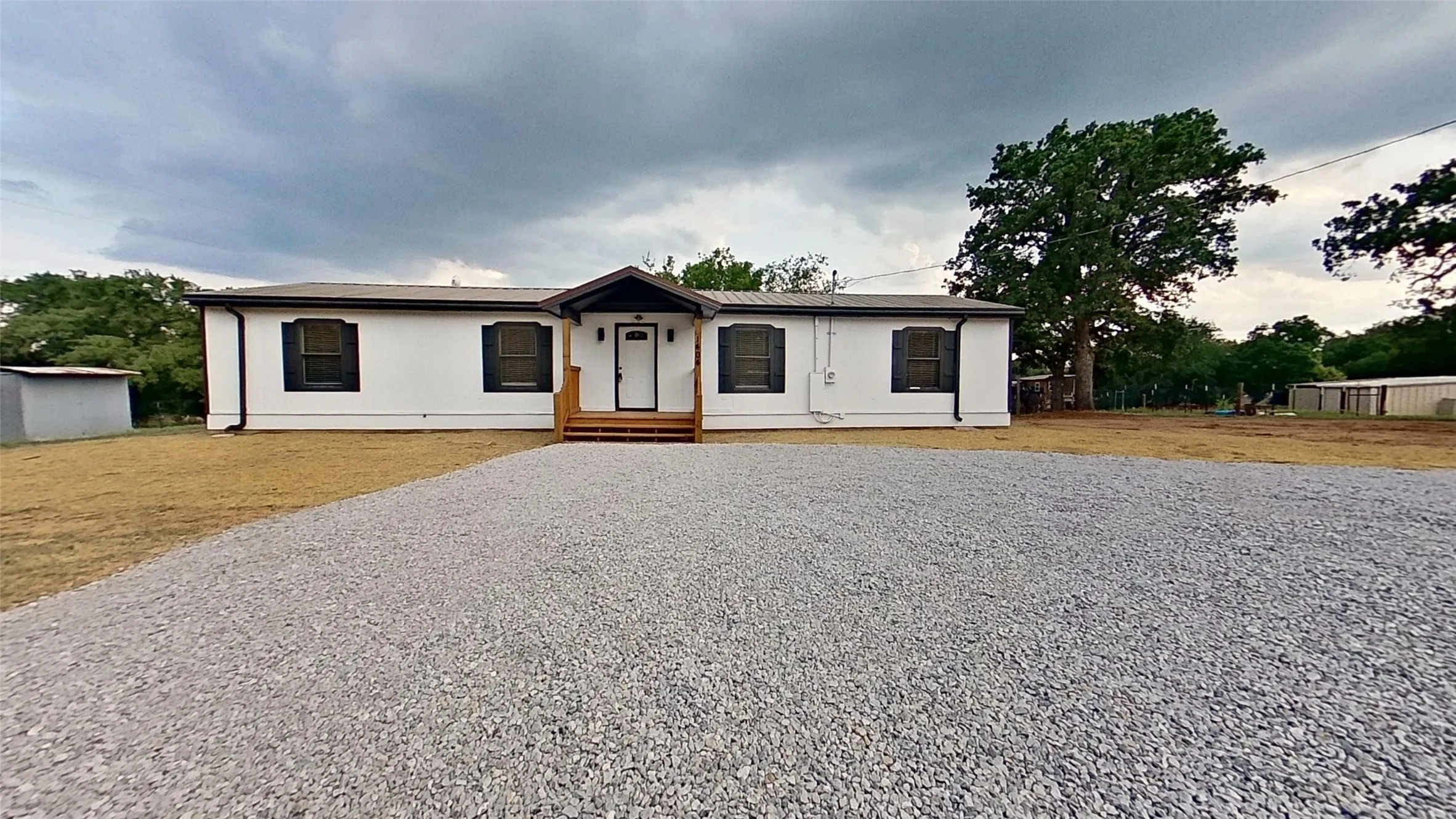 White single-story residence featuring a dark roofline and coordinating window shutters