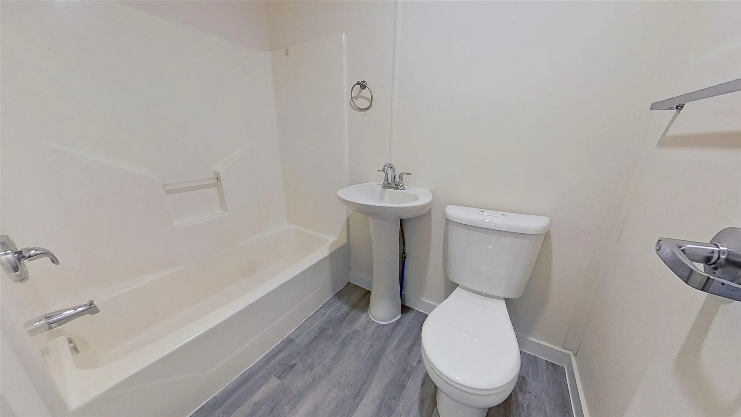 Bathroom featuring a pedestal sink, toilet, and bathtub with integrated shower