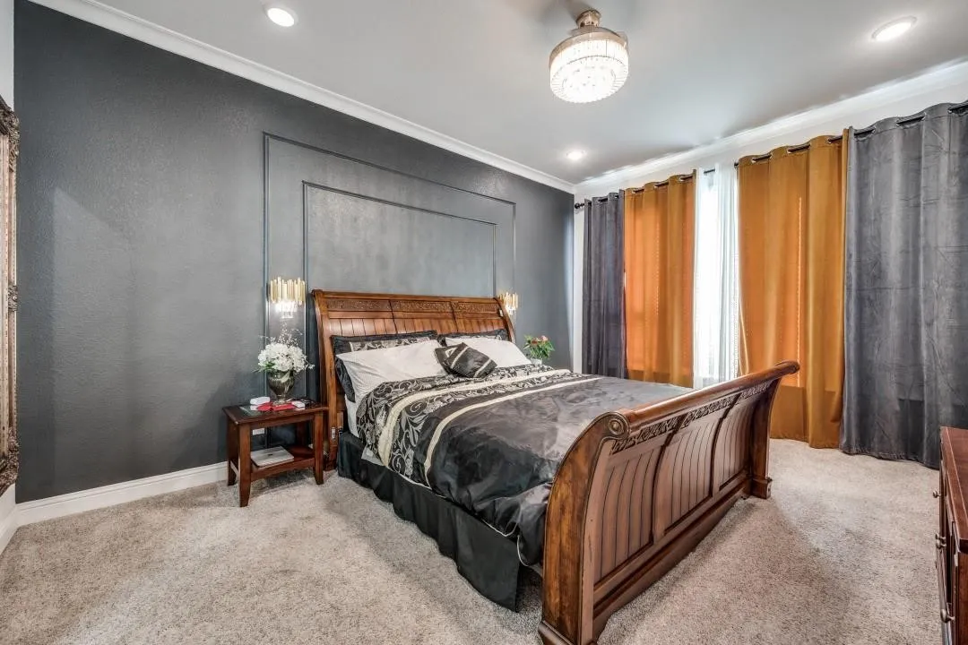 Carpeted room featuring a decorative wall panel accent, recessed lighting, and a prominent chandelier