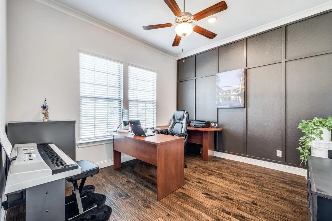 Spacious interior room featuring wood-finish flooring, a decorative accent wall, and crown molding
