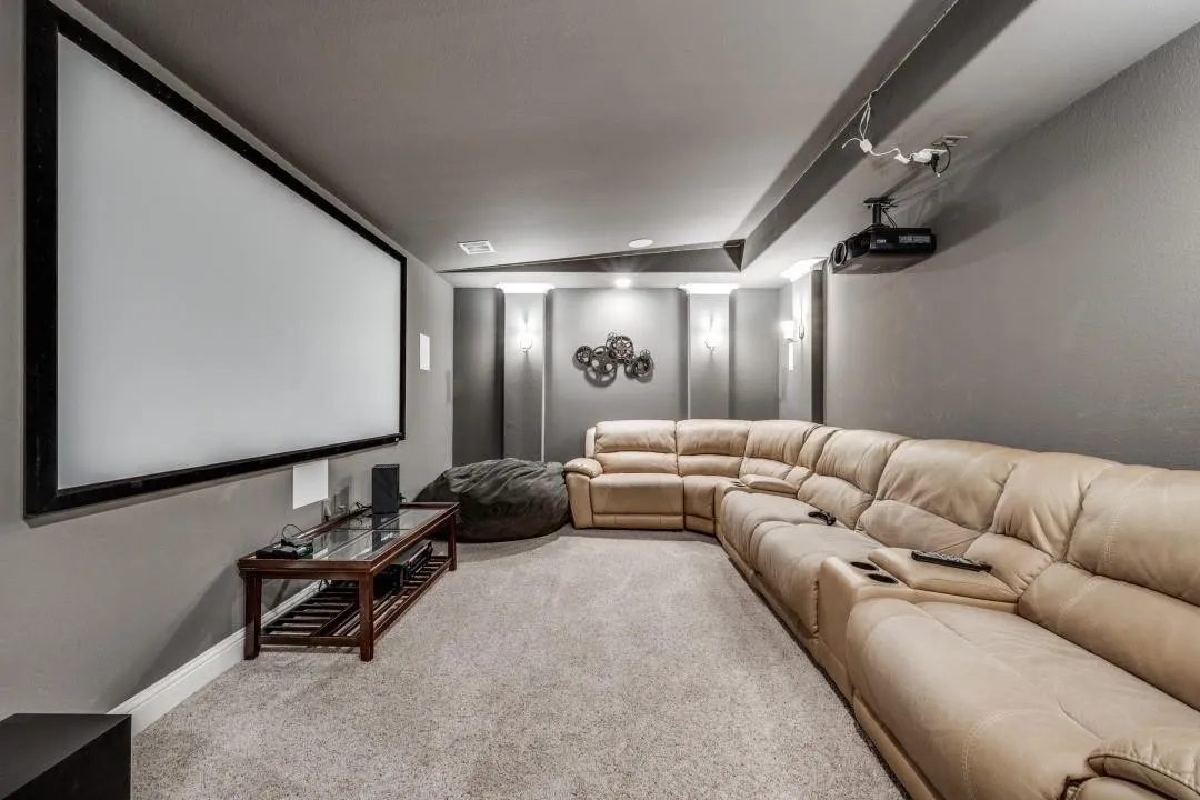 Dedicated media room featuring a large projection screen and wall-mounted projector