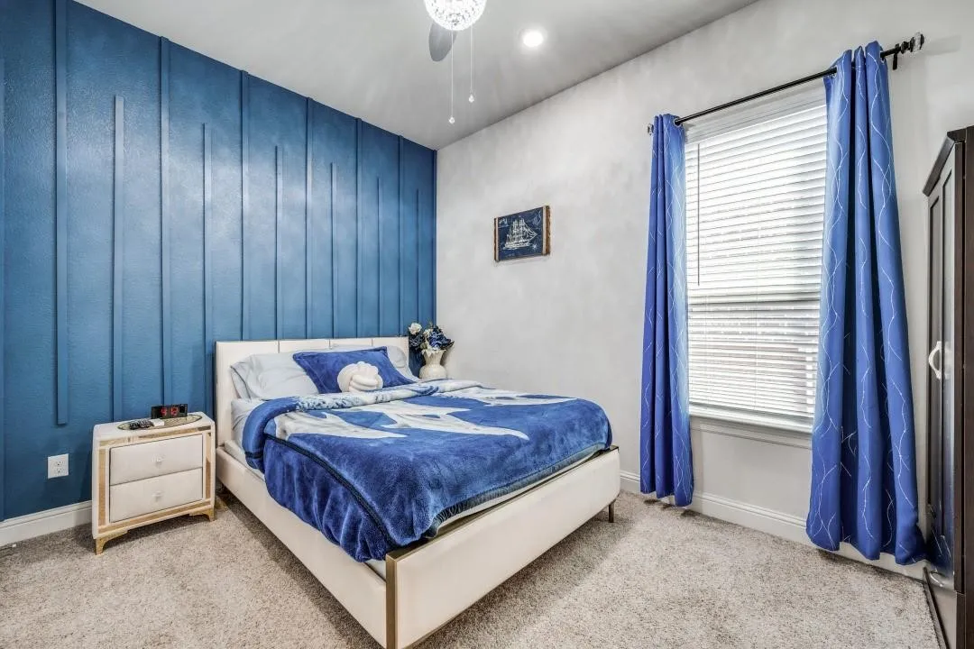 Accent wall featuring vertical paneling, light-colored carpeting, recessed lighting, and a window with blinds